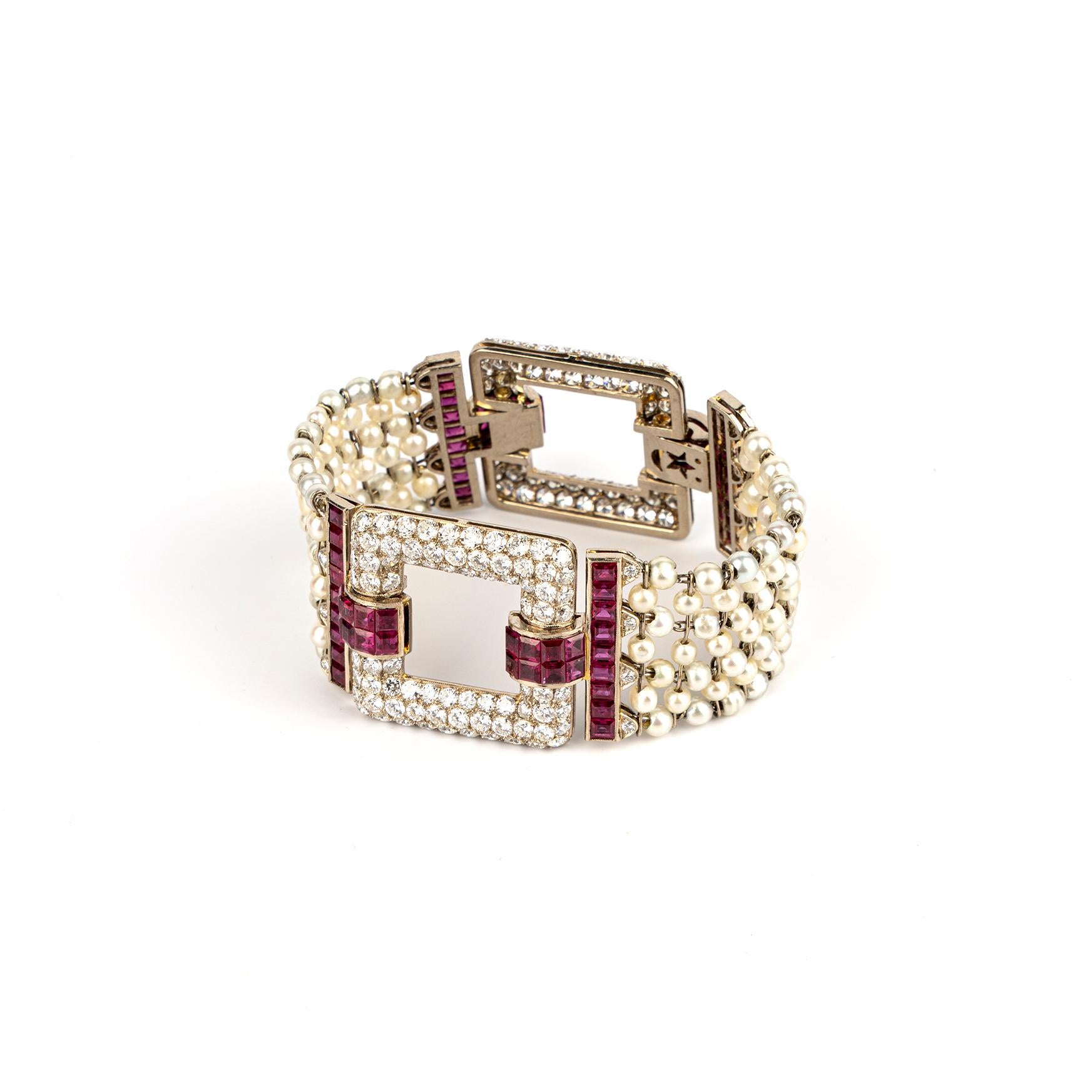 A sumptuous Art Deco Bracelet showcasing seven rows of natural pearls linked to two beautiful Ruby and Diamond Clasps. The bracelet is accompanied by its original box from George H. Newstedt of Cincinnati. Made in America, circa 1920.