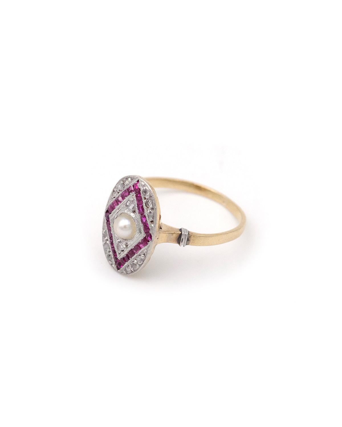 Art-Deco-Ring mit Perlen und Rubinen aus 18 Karat Gold und Platin. Ein ovaler Ring aus den 1930er Jahren mit einer Zuchtperle in der Mitte, akzentuiert durch kalibrierte natürliche Rubine, die in einem Rautenmuster angeordnet und von Diamanten im