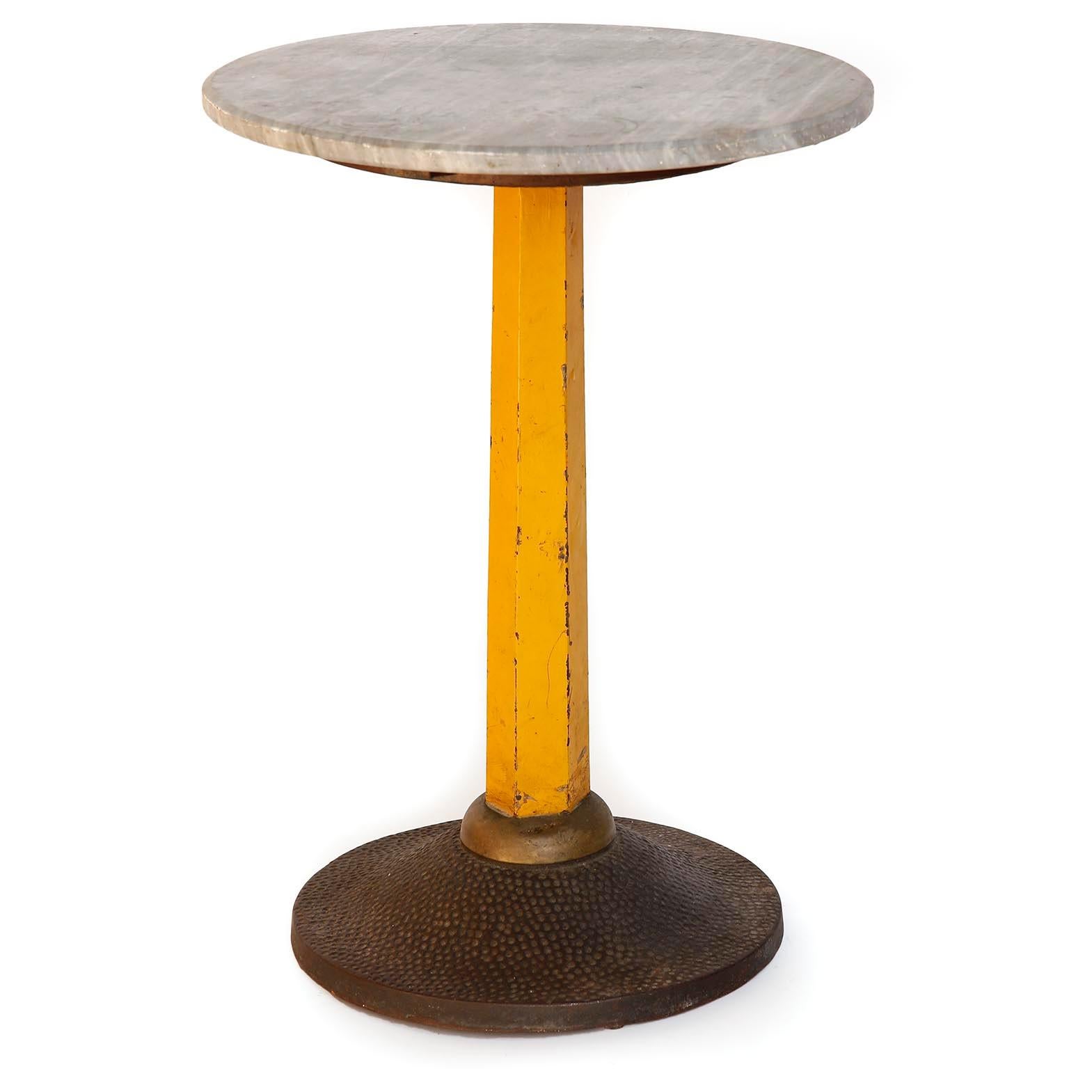 A pedestal table by Carl Witzmann made of grey marble, a yellow metal stand, and a cast iron base.
Carl Witzmann designed the 'Café Esplanade Zauner' in Bad Ischl, Austria, which opened in 1927. This table was part of that interior.
The table is in
