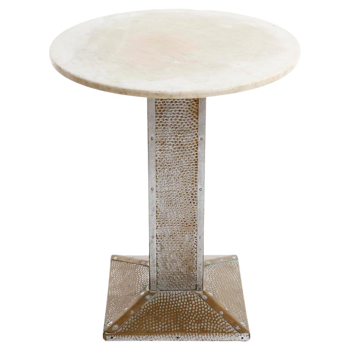 A pedestal table made of marble and a hammered and nickeled brass stand, manufactured in Vienna circa 1910.
Partly the nickel plating is no longer present and the brass underneath is visible. There is great patina on nickel, brass and marble.
The