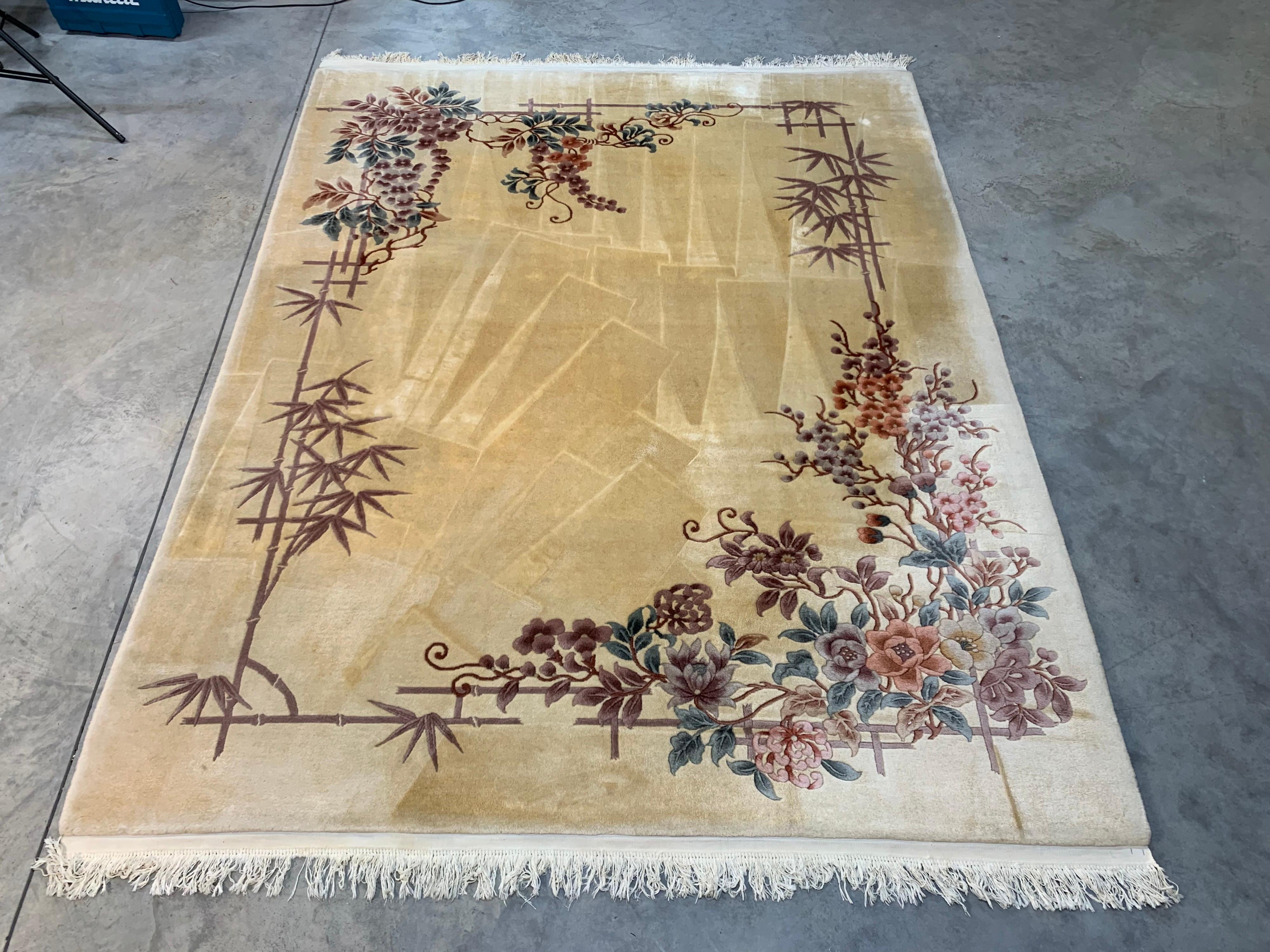 A beautiful 8 x 10’ Art Deco Revival Oriental throw rug having vegetable dyed bamboo and floral patterns. Hand woven and professionally cleaned. Striations seen in the image are from the cleaner and streak to the lighter color tones when you wipe
