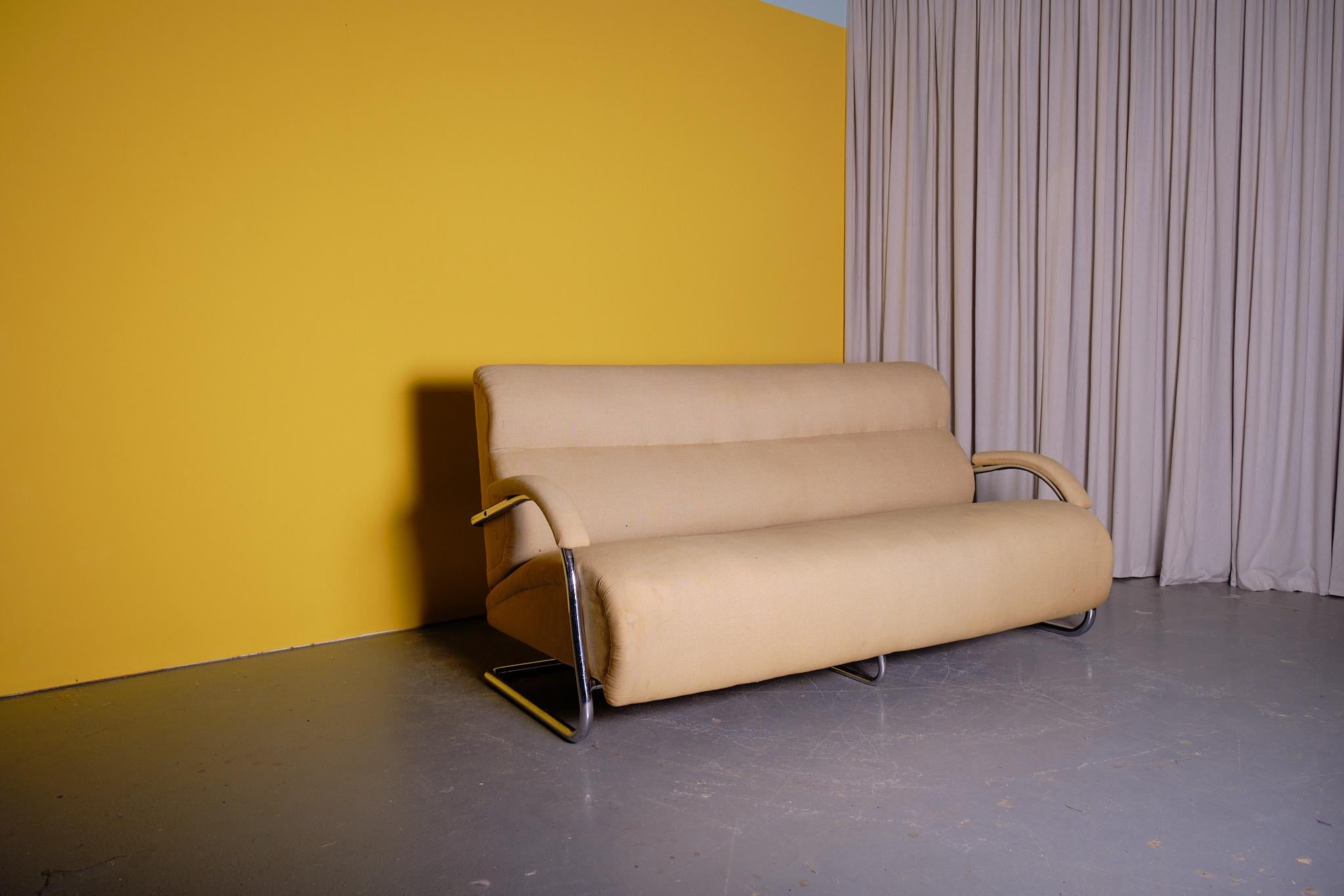 An elegant and rare tubular steel modernist sofa attributed to PEL (Practical Equipment Ltd) The chromium plated steel wraps around the back and forms the armrests. It is upholstered in an old neutral textile and is ready for recovering. This sofa