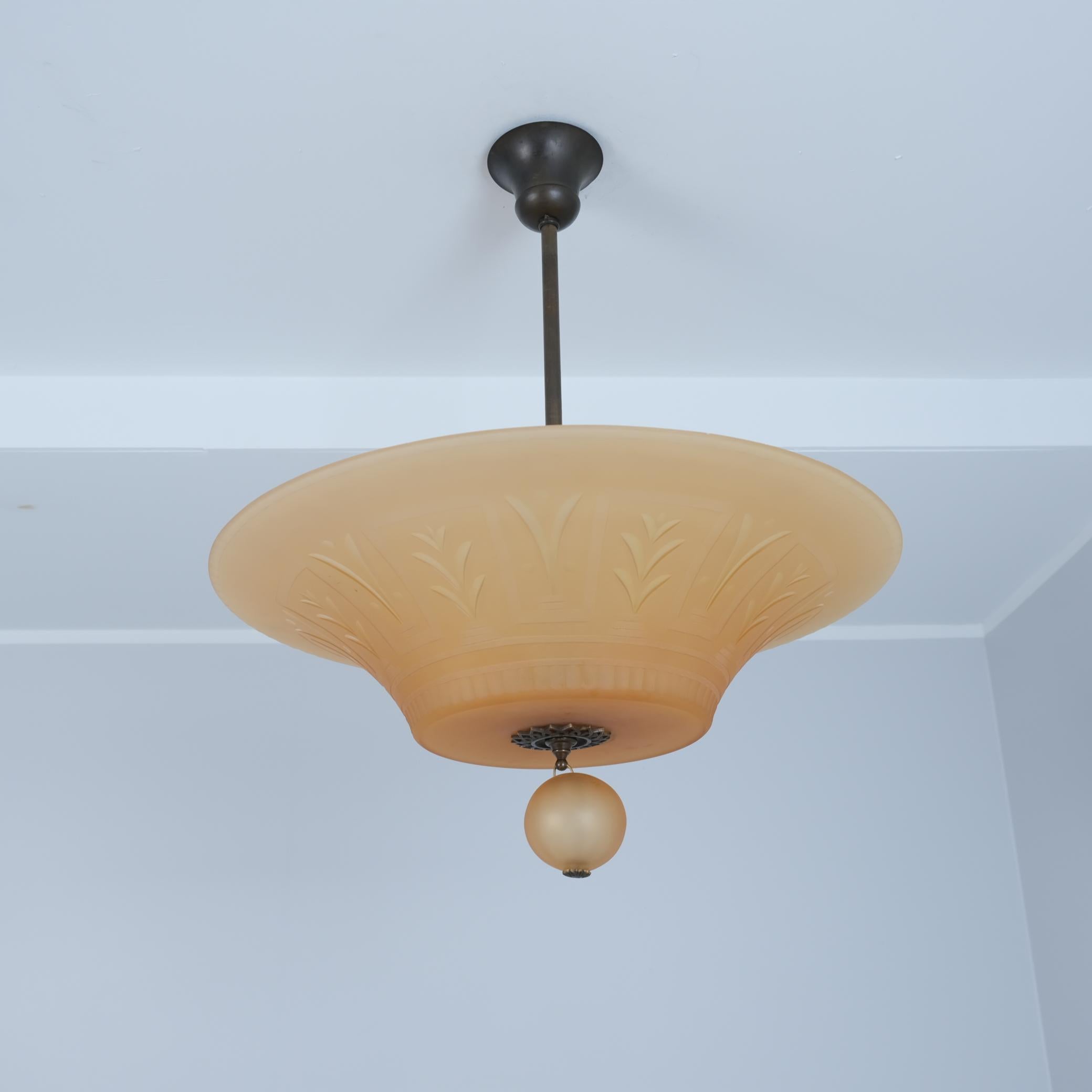 Un bellissimo paralume in ottone art déco e vetro color ambra con decorazioni tagliate che rappresentano la grazia svedese degli anni 1920-1930. Prodotto da Orrefors. Il paralume originale color ambra ha tagli decorativi art deco ed è piuttosto