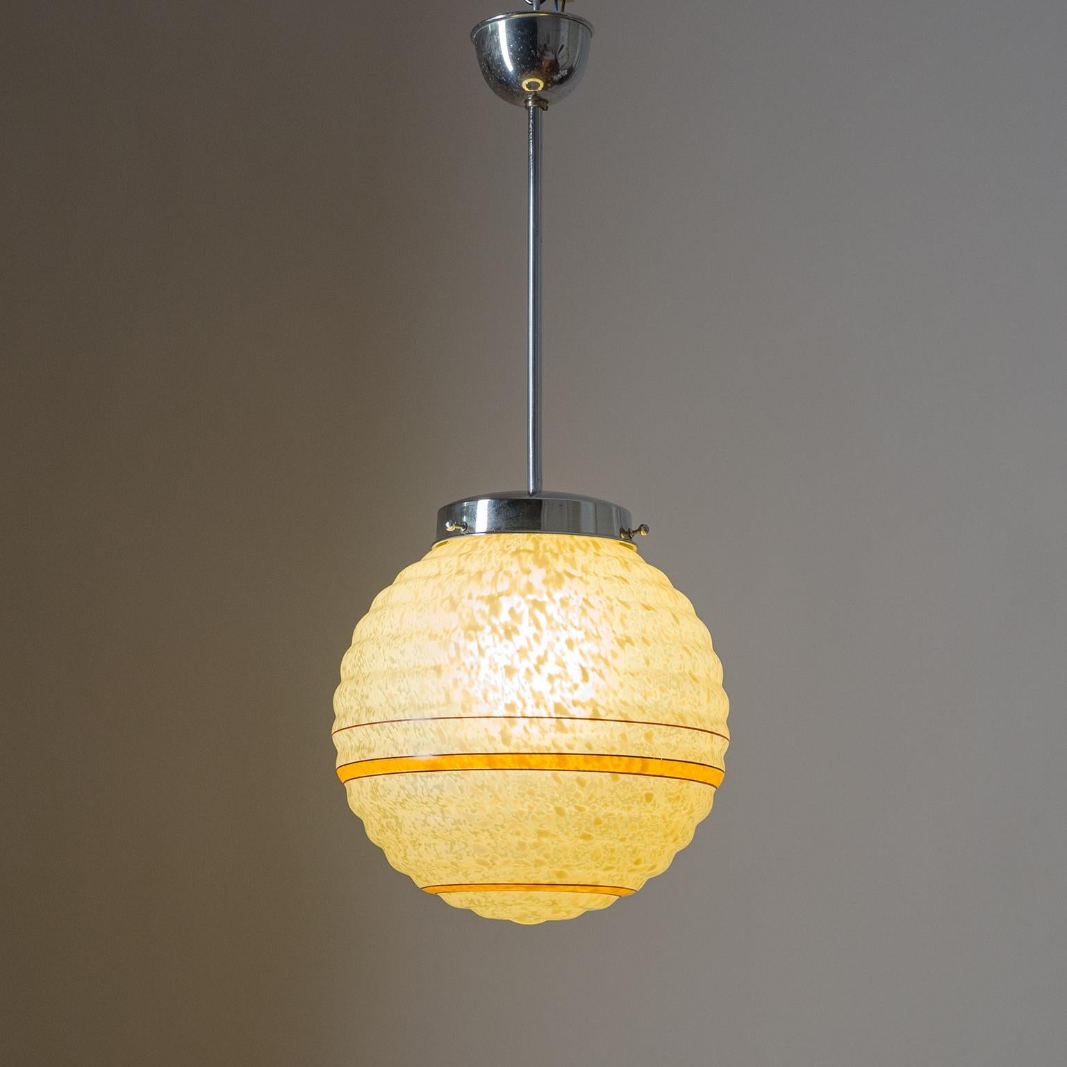Art Deco pendant or lantern with a ribbed glass globe and chrome hardware. The ribbed globe is made of mottled amber glass with a satin finish and painted 'Saturn' rings. Fine original condition with one original brass and ceramic E27 socket and new