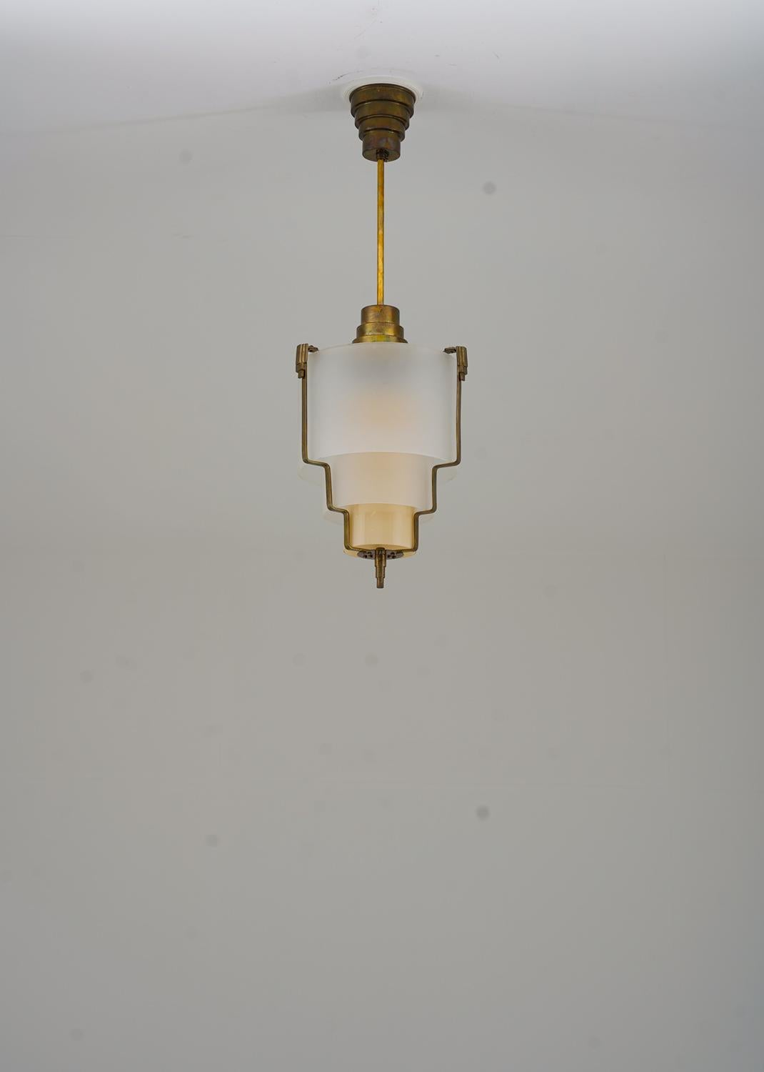 Elegant pendant in brass and blasted glass, most likely produced in Sweden, probably 1930s. 
The lamp consists of three cylinder-shaped glass shades, held in place by a brass frame.

Condition: Very good original condition.

***
PLEASE NOTE