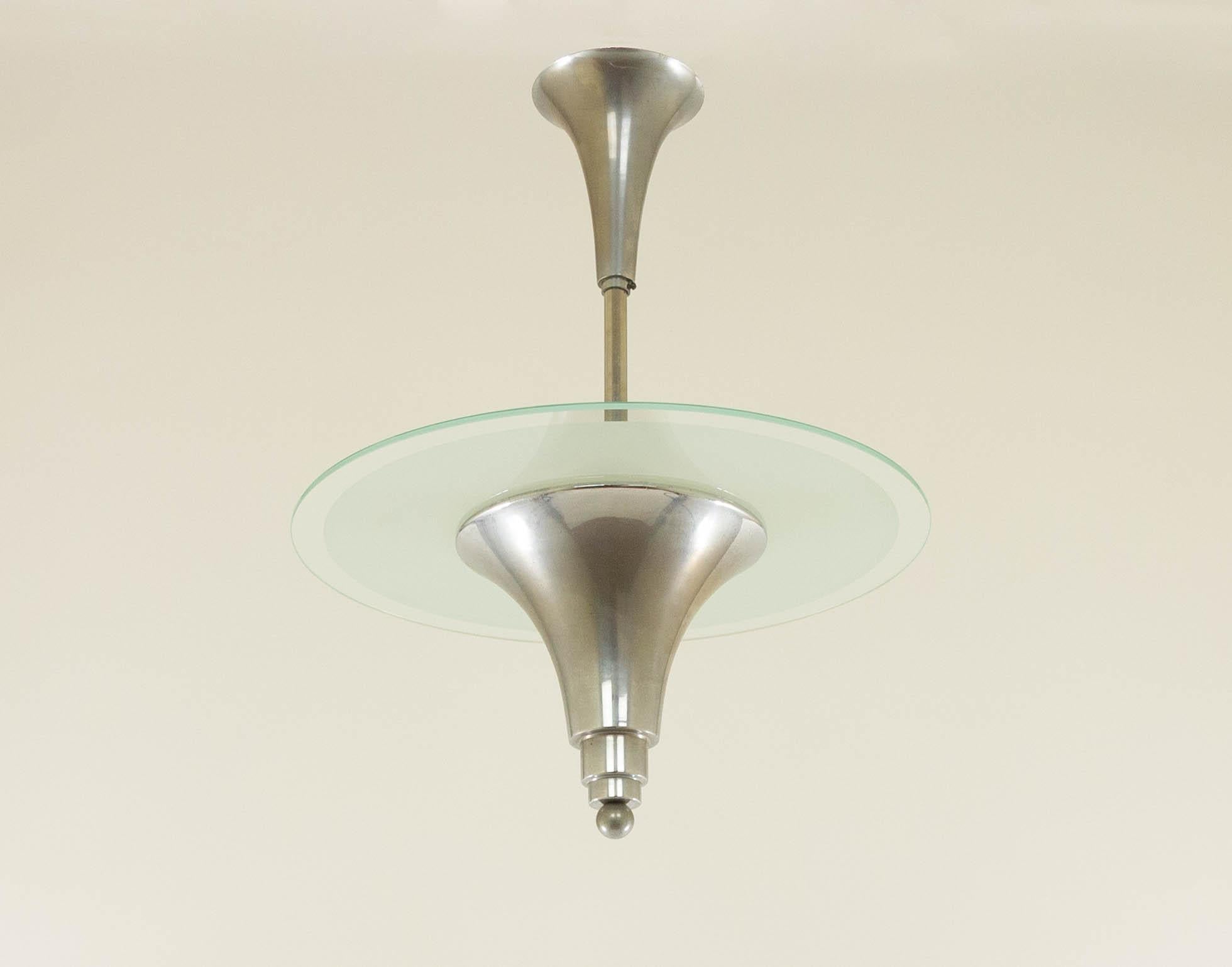 Characteristic Art Deco pendant light made of nickel and frosted glass; designed and manufactured in France around the 1930s.

The lamp is in good vintage condition. The inner circle of the glass plate - which is not visible because it lies on the