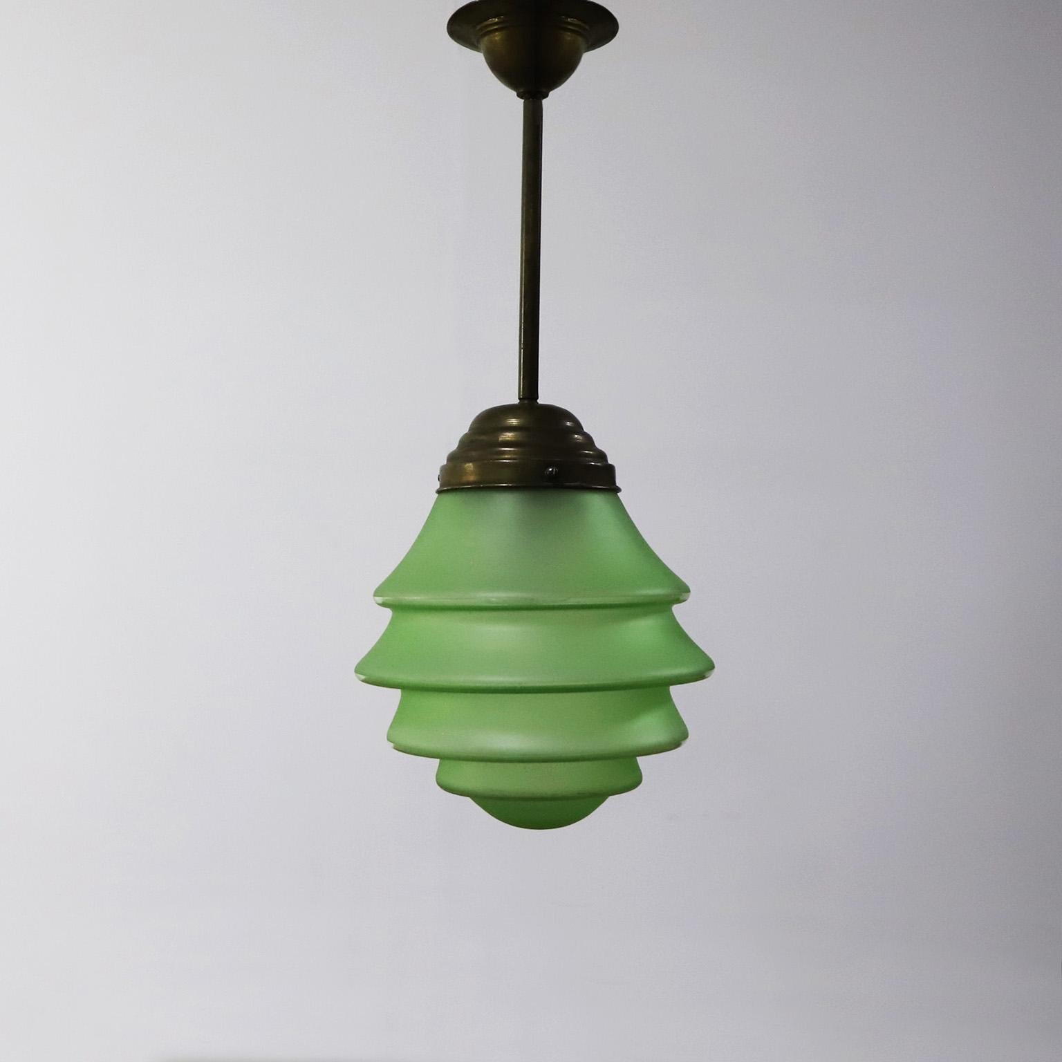 Circa 1930. We offer this Art Deco Pendant Light in Rare Green Opal Glass and Brass, Absolutely a very rare and difficult to find piece due to its beautiful colors, shapes and materials. A beautiful piece of porcelain supports the wire.