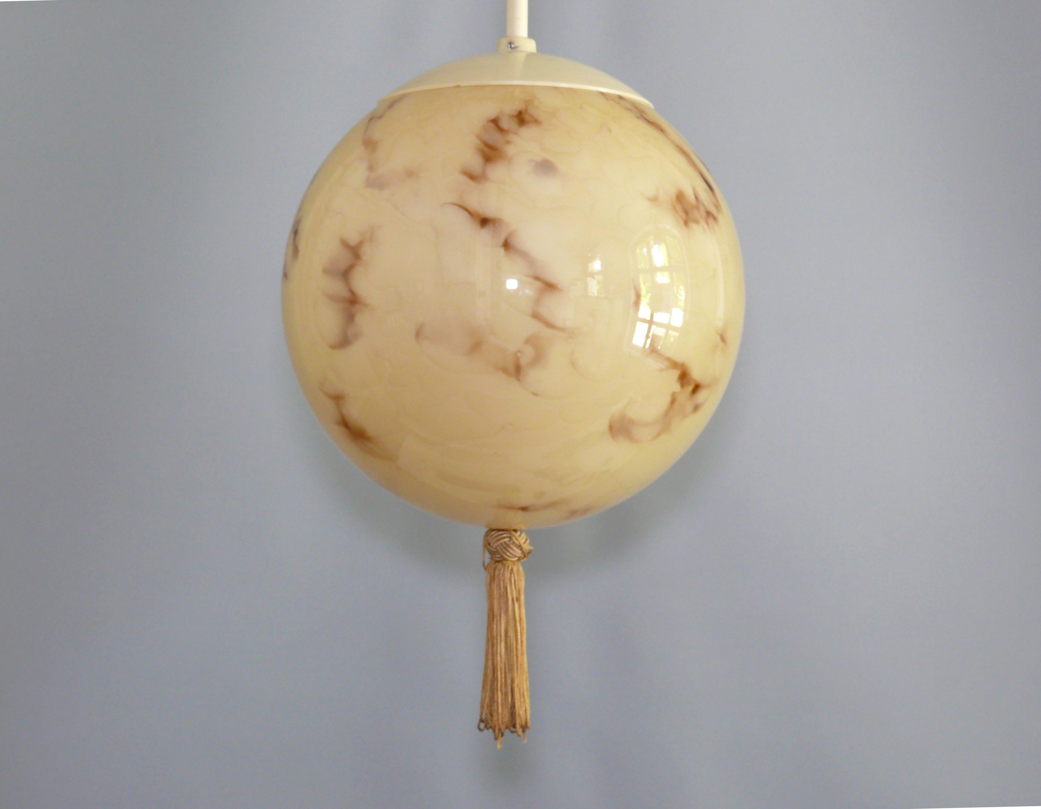 Art Deco ball lamp with rod suspension, tassel and marbled glass shade. The beige glass shade is crossed by brown stripes. The lamp dates from the first half of the 20th century (1930 - 1950). The glass shade is in perfect condition, the metal and