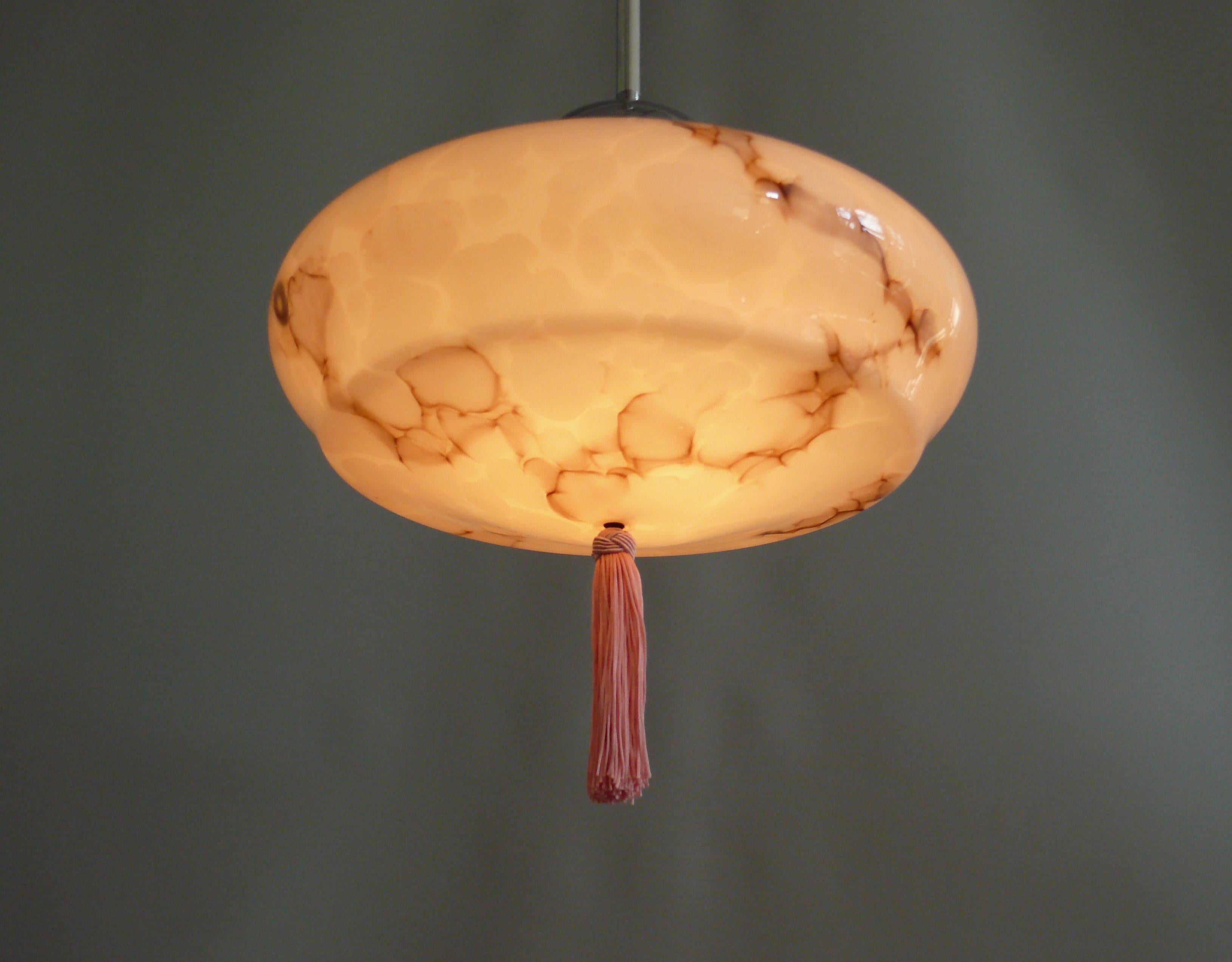 Elegant, pink Art Deco rod pendant light from the first half of the last century - 1930s - with a domed glass shade.

This rod pendant light looks particularly good in high-ceilinged rooms with antique furniture.

The pink glass shade has a