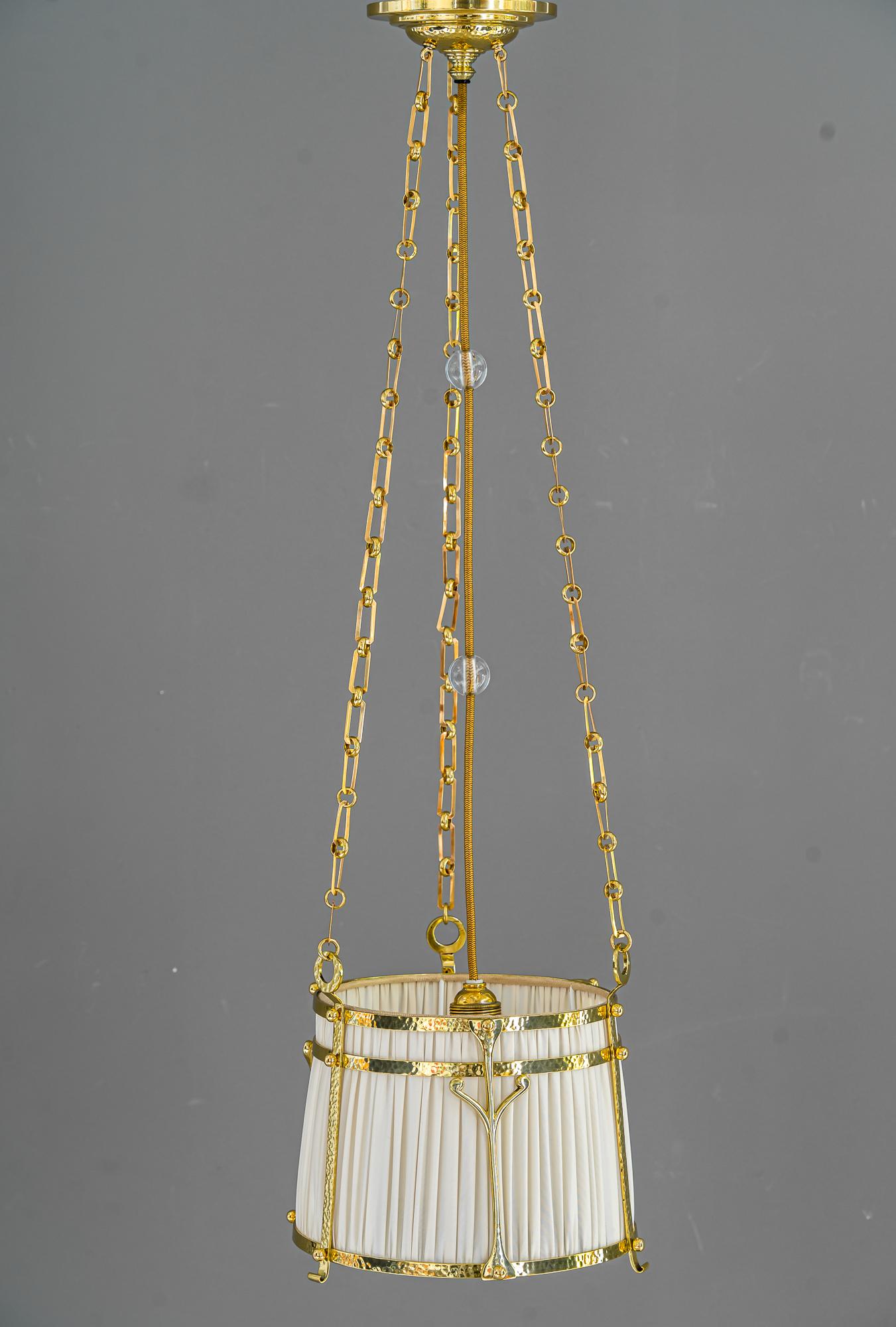 Art Deco pendant, Vienna, around 1920s.
Polished and stove enameled.
Hammered brass and fabric shade.
The fabric is replaced (new).
 