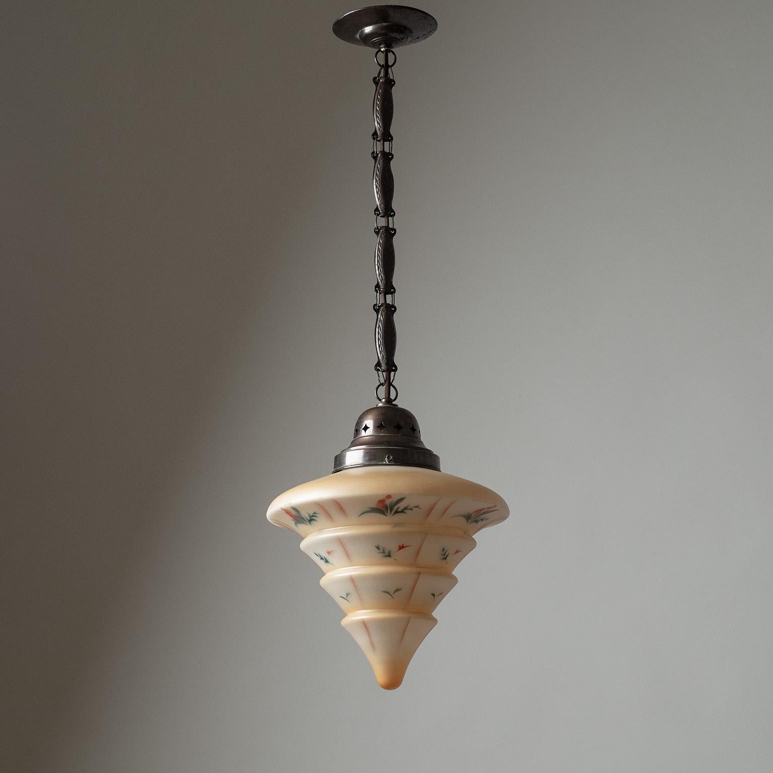 Rare Art Deco pendant in patinated copper with tiered and enameled glass diffuser from the 1920s. Intricately detailed copper hardware that has been patinated to a very dark hue. The satin glass diffuser is enameled in a pale peach color with floral