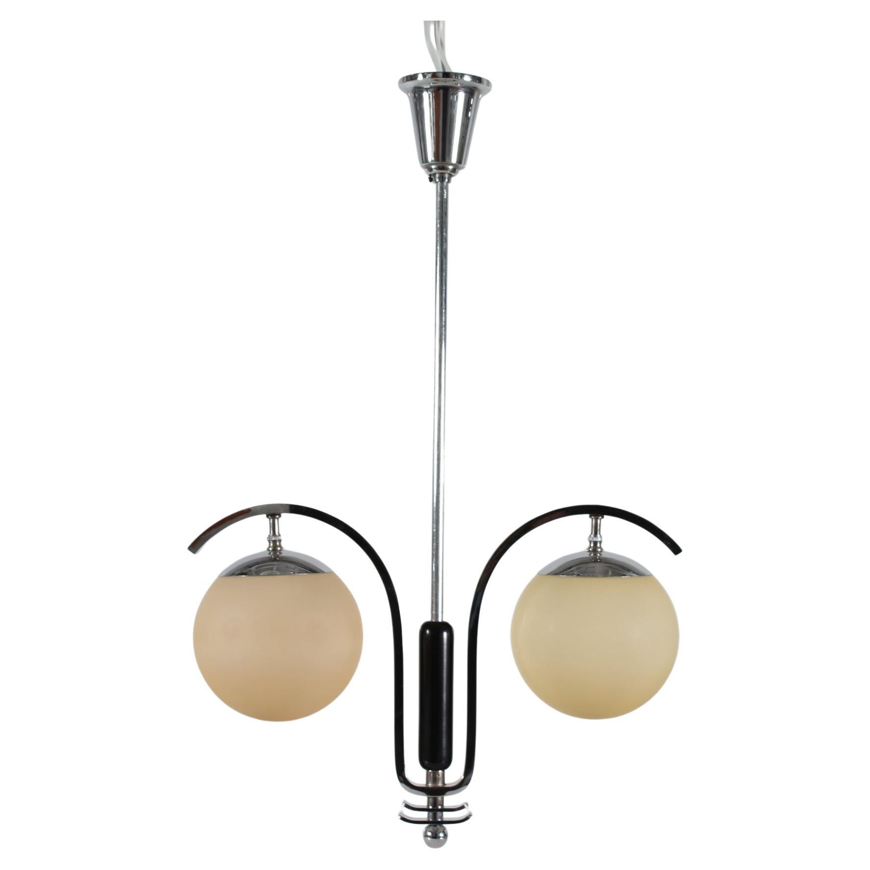 Art Deco pendant manufactured by the Danish Lamp company Fog & Mørup or Lyfa in the 1930s.
The frame is made of shiny chromium plated metal with middle piece of wood with black lacquer. The shades are made of beige colored matte glass.

Height incl.