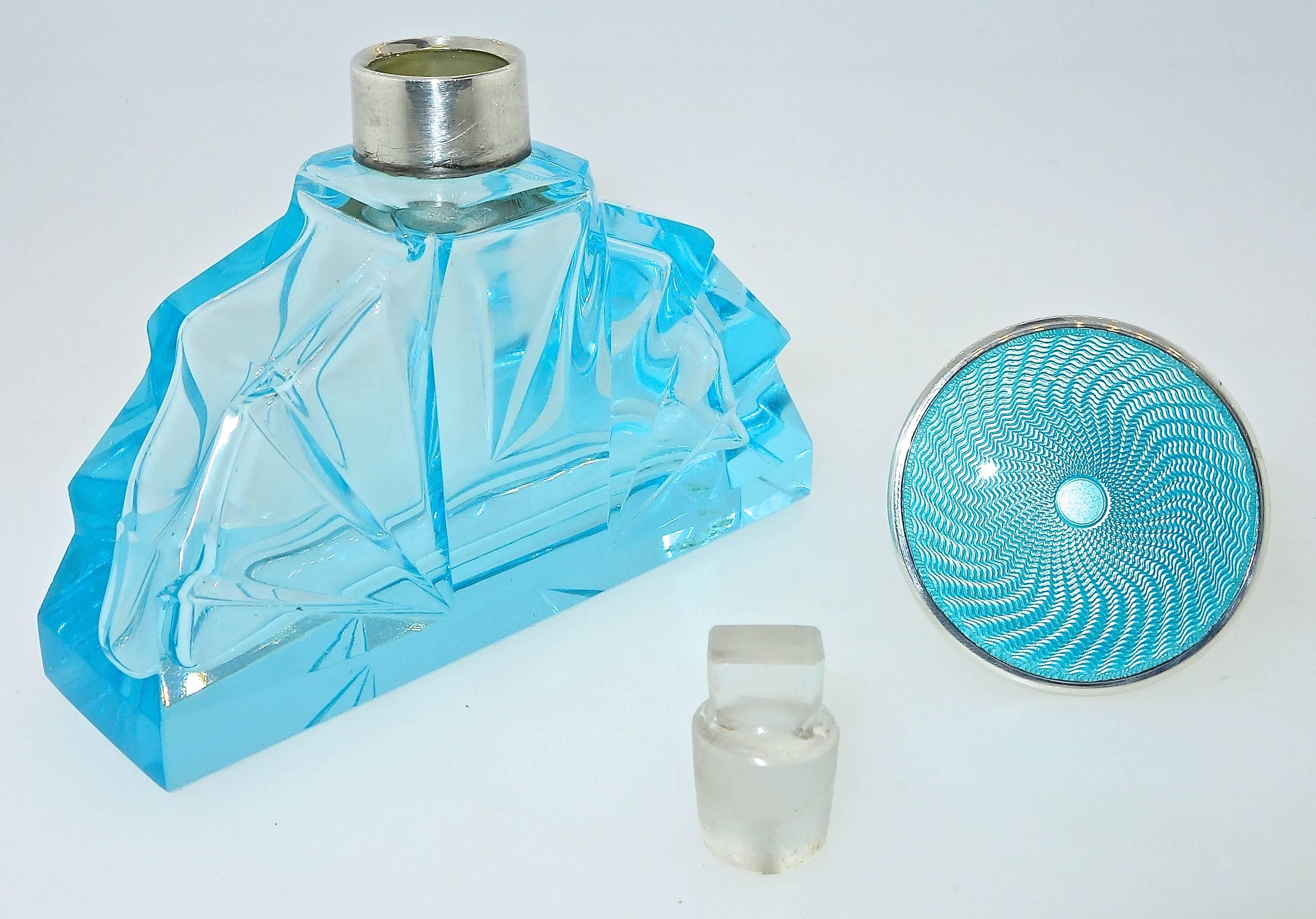 The top or lid is sterling silver with fine aqua blue guilloche enamel.  The cut glass bottle matches in color the top lid. This perfume bottle has the original 