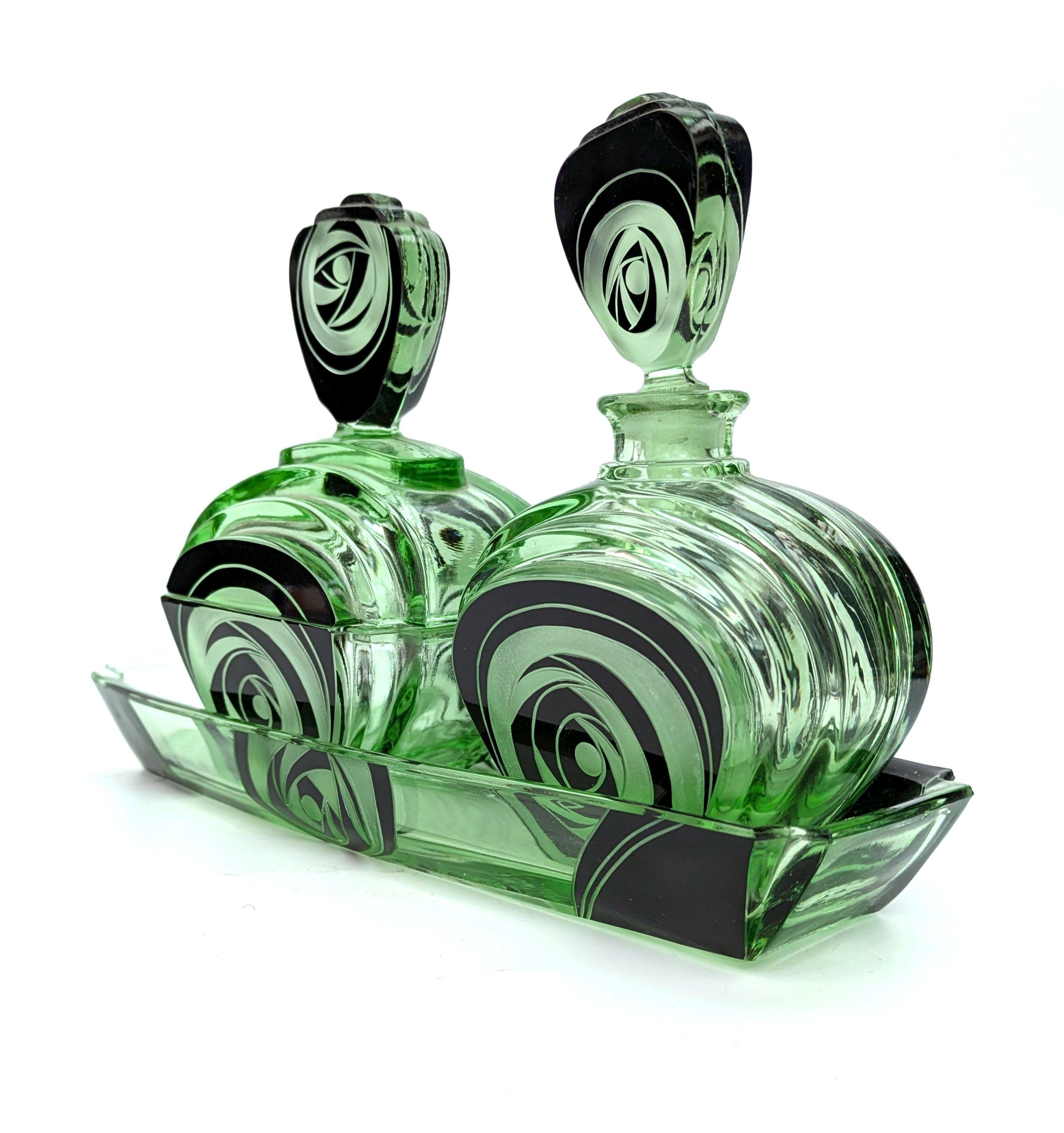 Very striking and unusual Czech glass dressing table perfume set on it's matching tray. Adore the shape of the glass which has a stepped streamline effect. The bold black enamel against the green is also very appealing and works perfectly together.
