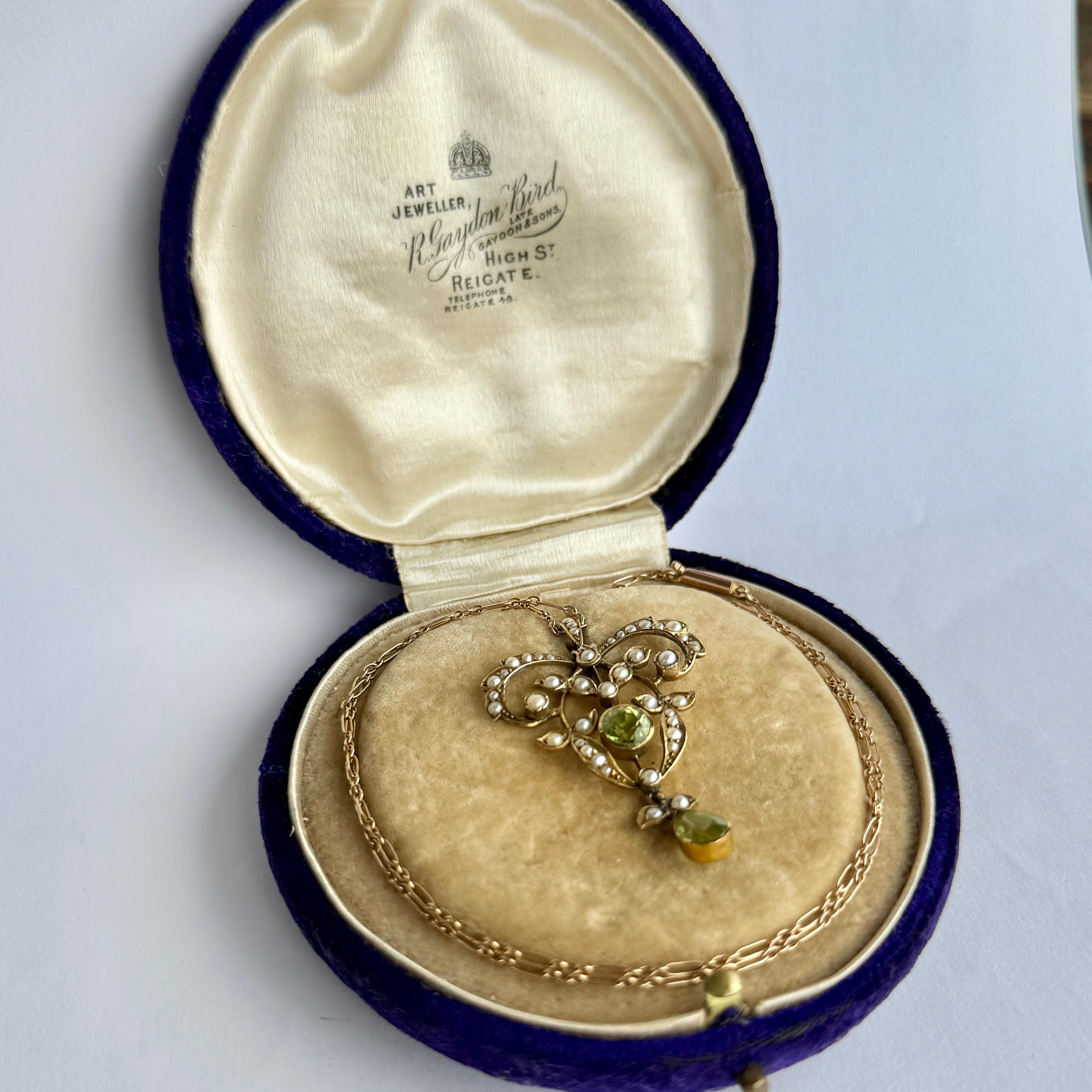 Questo ciondolo contiene due pietre di peridoto di 60 e 50 carati ed è realizzato in oro 9 carati. Il ciondolo è anche incastonato con perle di semi. Viene fornito in una scatola d'epoca.

Lunghezza della catena: 40 cm
Ciondolo da cima a fondo: 4.2