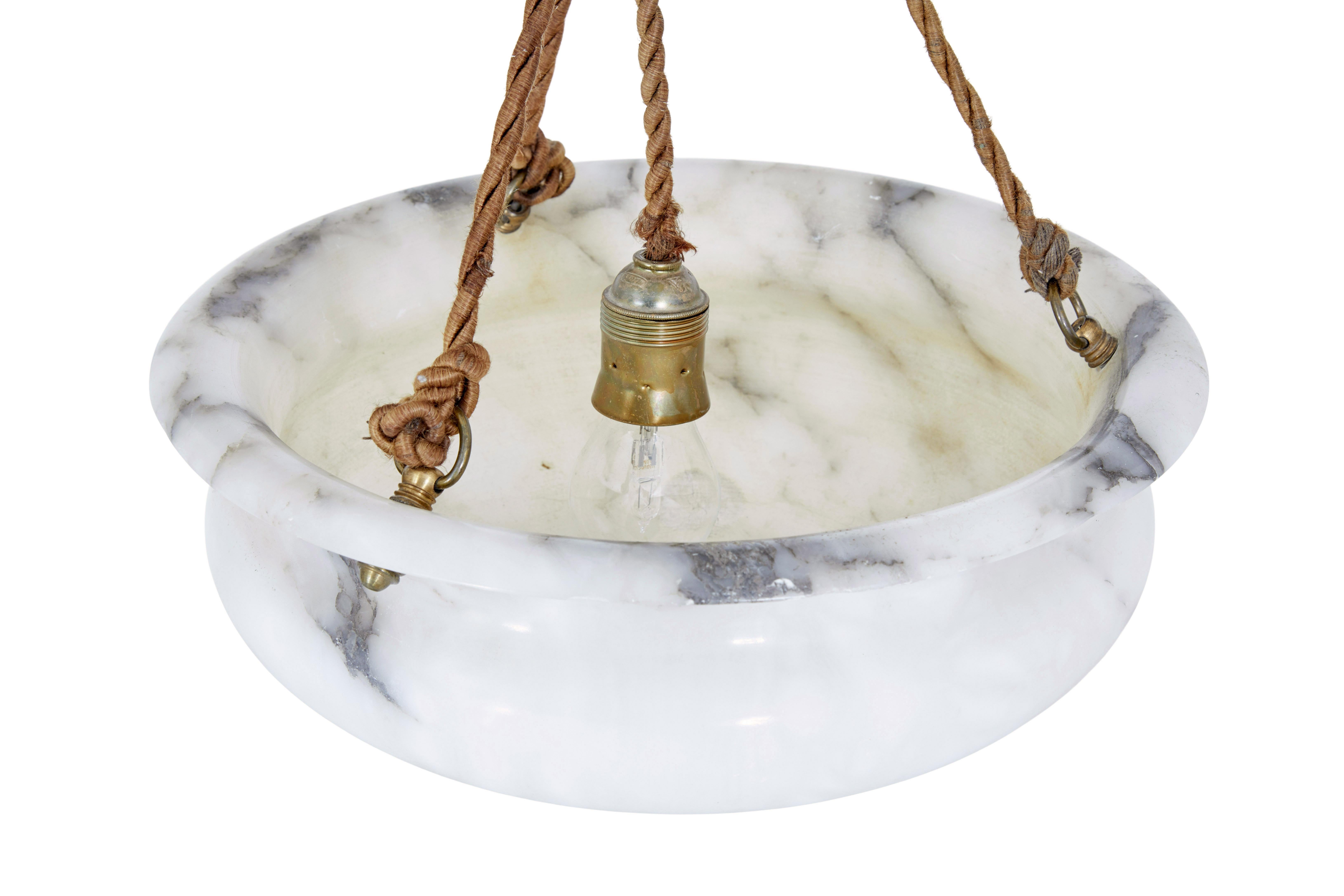 Art deco period alabaster hanging pendant light circa 1930.

Fine quality hand made alabaster light which has been turned and hand carved.  Round bowl with lipped edge, hand carved with a central circular fan in the centre of the base.

Light is