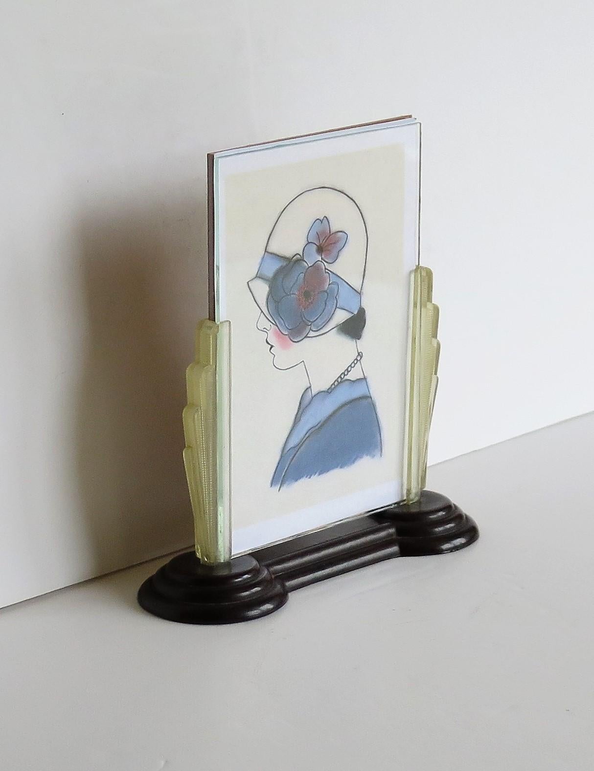 This is a beautiful photo frame from the Art Deco period, made from bakelite with fan shaped sides and with a glass insert, which we date to circa 1930.

The design of this piece is very 