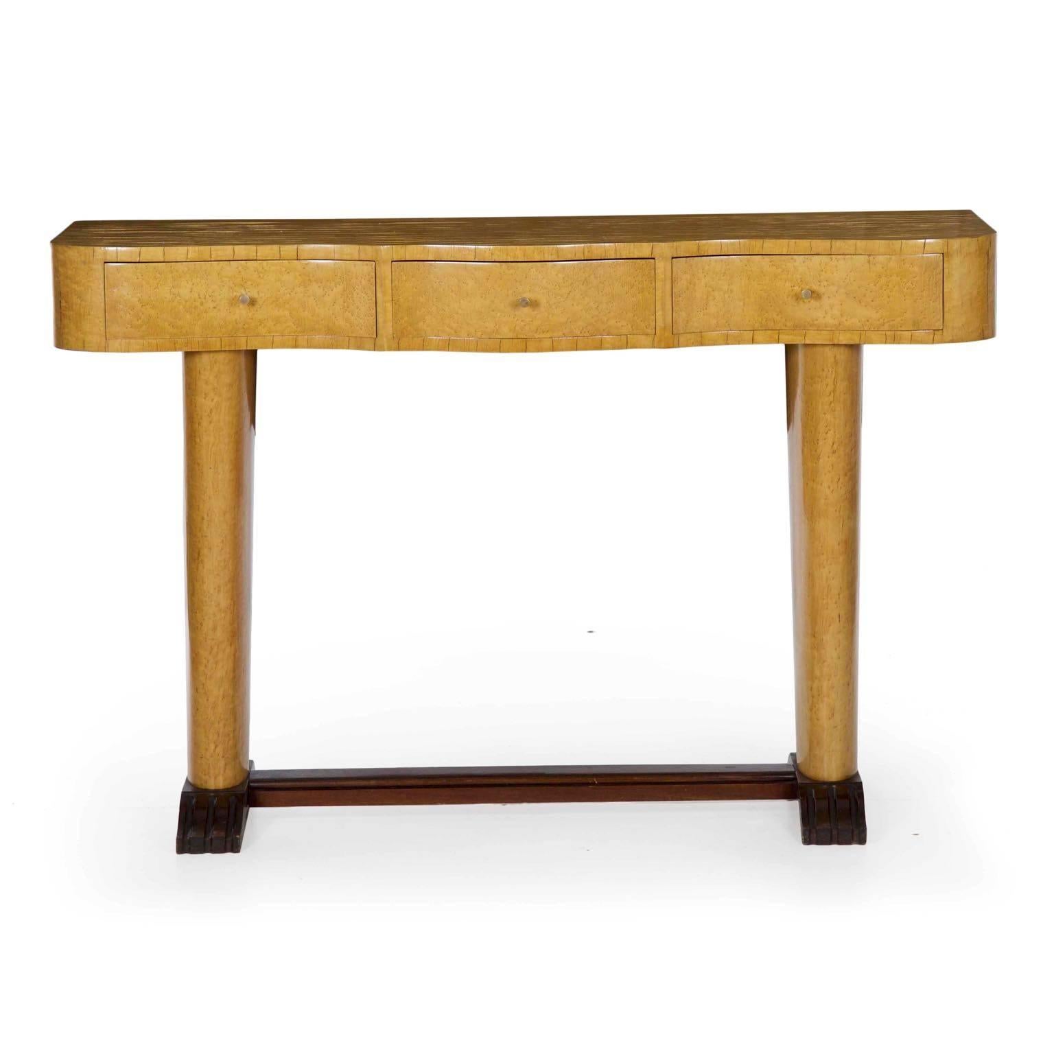 A rather striking three drawer console table from the Art Deco period, it was retailed by the firm of Isaac Teperman in Brazil and retains the export stamps on the reverse. Interestingly, the console is dressed in what appears to be bird's-eye
