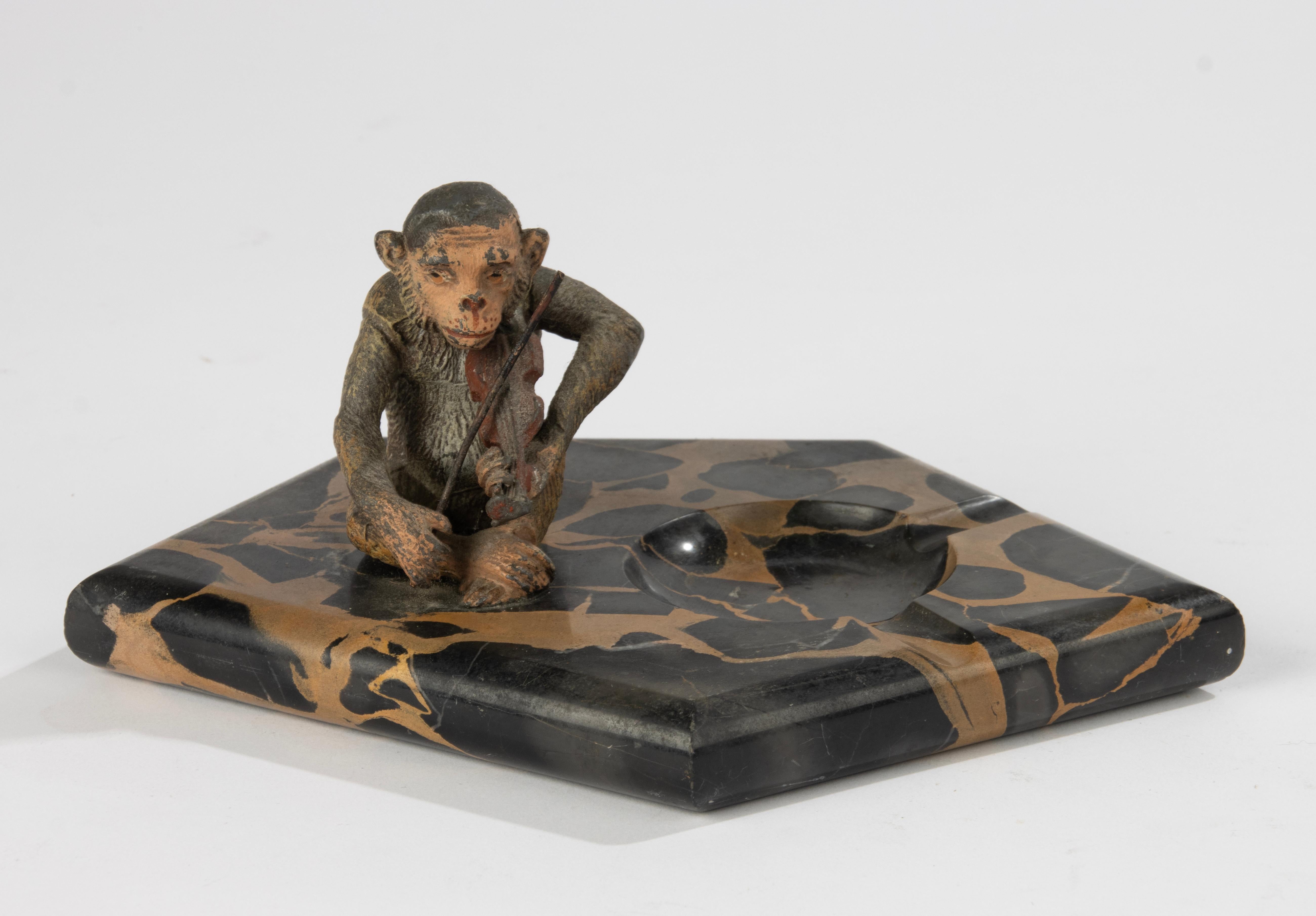 Precioso cuenco decorativo (cenicero) del periodo Art Déco.
De mármol Portoro Nero, con una simpática escultura de un mono con un violín. La escultura está hecha de zamak (espelta), bellamente patinado con diferentes colores.
Este objeto está en