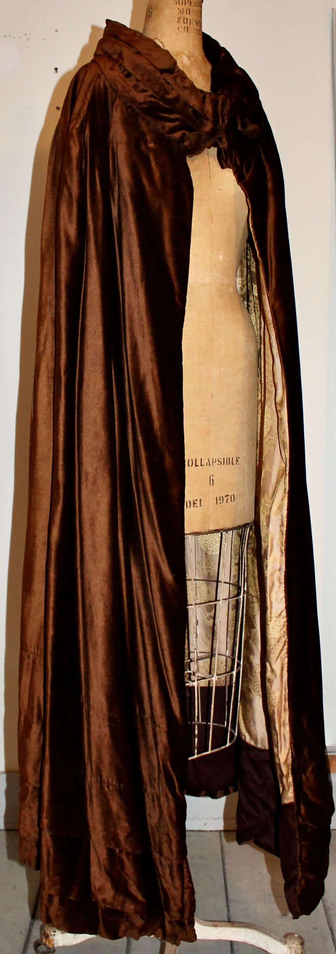 In velluto di seta marrone. Foderato con un tessuto di seta intrecciato con disegni deco.  Il capo misura 55