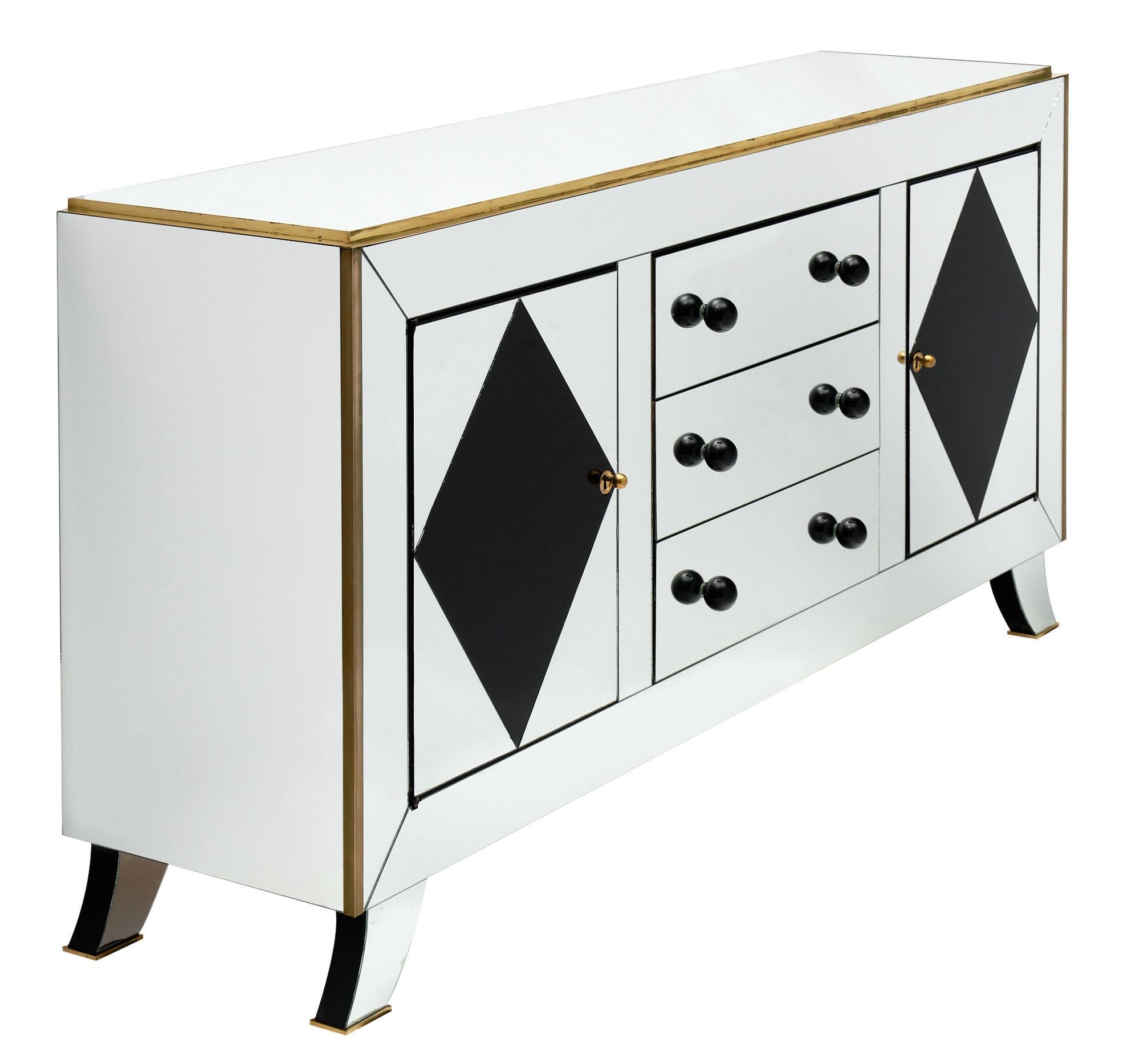 Art Deco period buffet with mirrored veneer over solid cherry wood. This French piece has gilt brass trims throughout as well. Murano glass knobs adorn the three central drawers and on each side a door opens outward with working locks and keys.