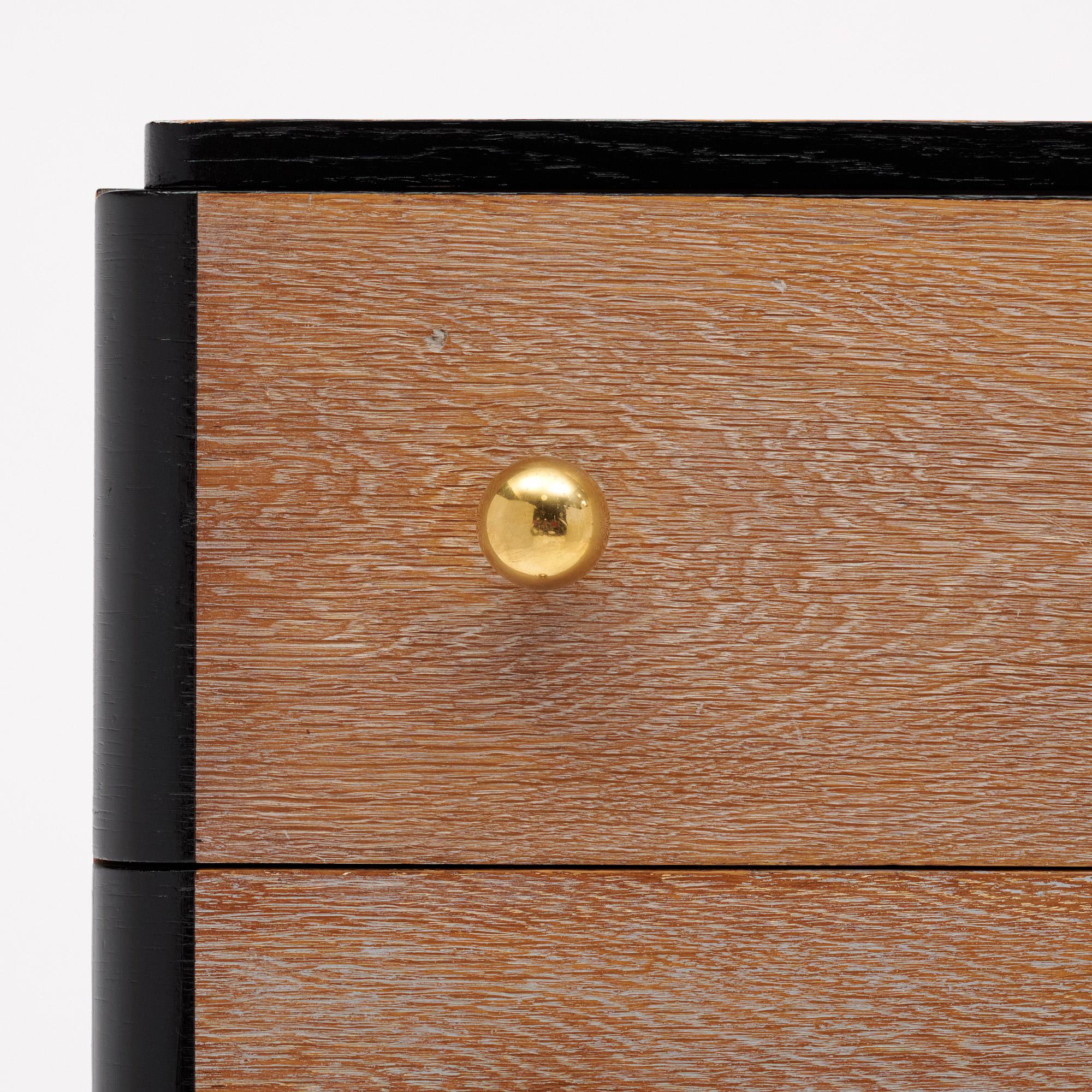 Kommode aus der Zeit des Art déco in Frankreich von der Stilikone Dominique. Dieses Stück hat zwei Schubladen mit Schwalbenschwanzmuster und Messingknöpfen. Die Kommode ist aus Massivholz gefertigt und mit einem 