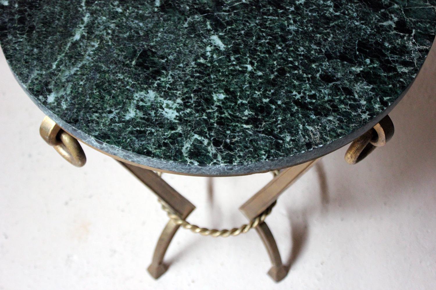 The very stylish Art Deco period occasional table having a super quality green serpentine marble top over a gilded metal base, with four angular supports to shaped feet, rope twist conforming stretcher and four drop rings to the frieze, the whole in