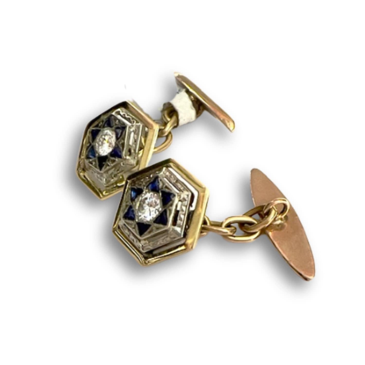 
Elevate your ensemble with these exquisite Art Deco cufflinks from the 1930s-1935s, crafted in 18-karat yellow gold with platinum accents, adorned with sapphires and diamonds. These cufflinks boast a unique charm, blending the warmth of yellow gold