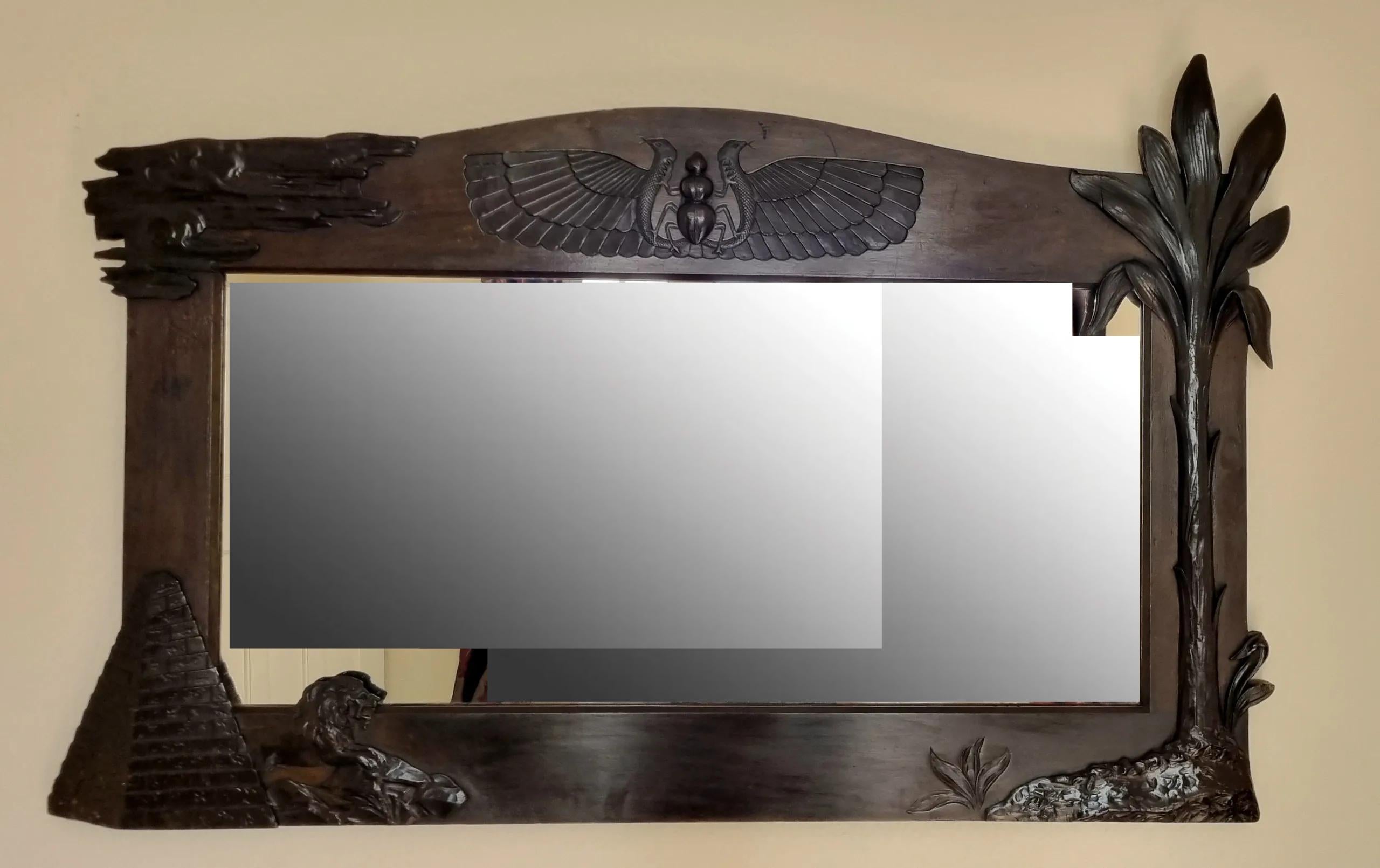 Rare miroir néo-égyptien de la période Diptych Fine Arts, finement sculpté dans du noyer massif et datant du milieu ou de la fin des années 1920. Inspirée par la fascination généralisée pour l'Égypte ancienne à la suite de la découverte du tombeau