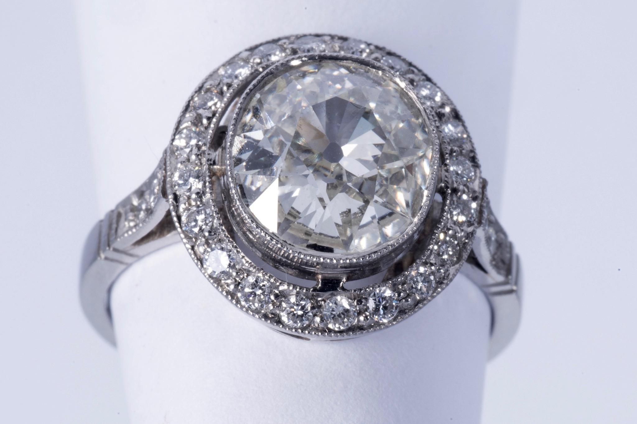 Fabulous European cushion cut diamond. The diamond weighs approx. 2.00cts and has J-K color and SI1 clarity. There is a halo with approx. 20 round cut diamonds and there are 2 round cut diamonds on either side of the shank. All together, the side