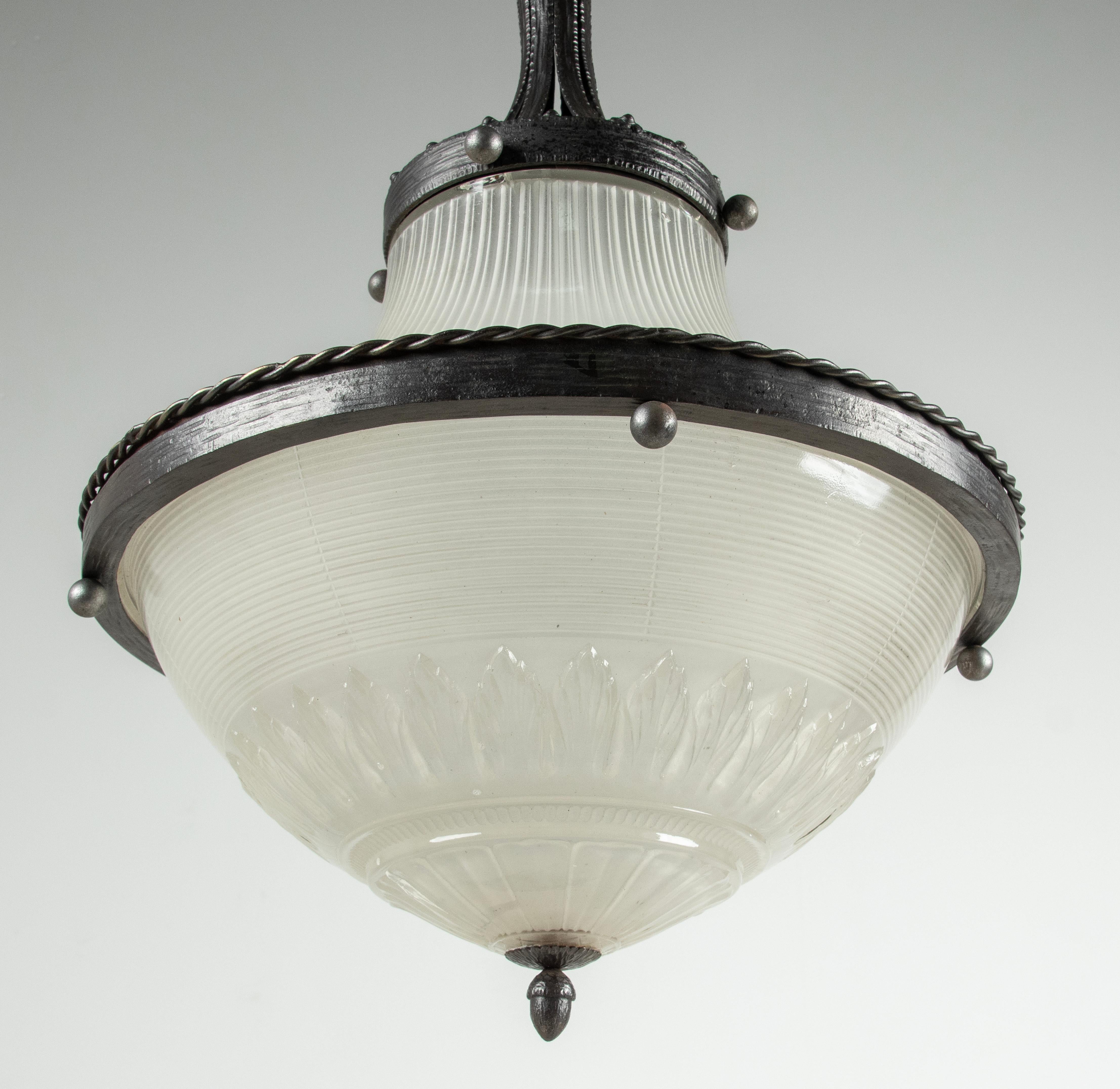 An elegant Art Deco chandelier or hall lamp. Made of refined patinated forged iron. With a satined glass shades. The lamp is rewired, it has one new E27 bulb holder. Made in France, around 1920-1930. Both glass shades are dismountable, for a secure