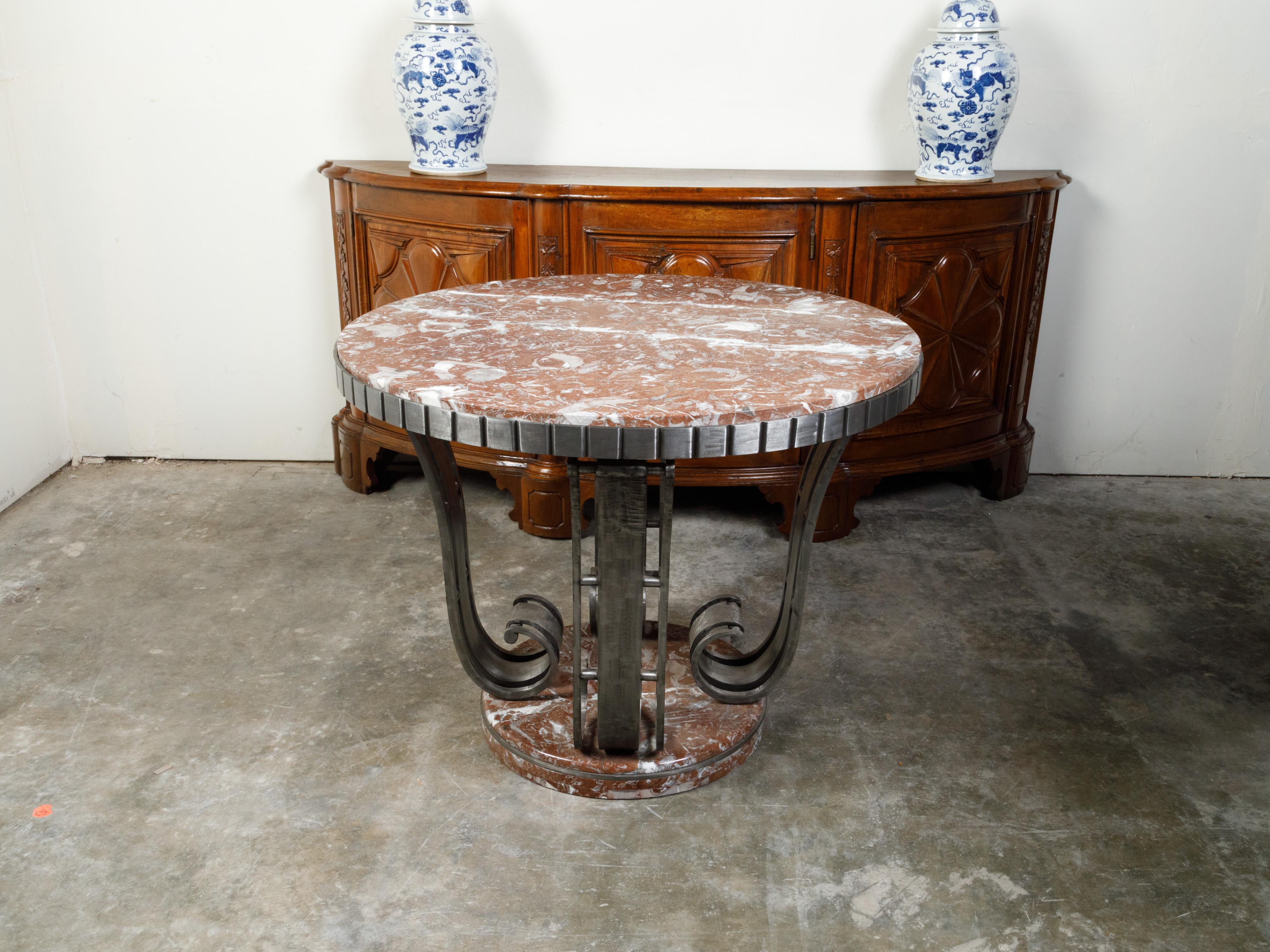 A French Raymond Subes Art Deco period side table from the early 20th century, with steel scrolling base and red marble top. Created in France during the first quarter of the 20th century, this Art Deco table features a circular red marble top