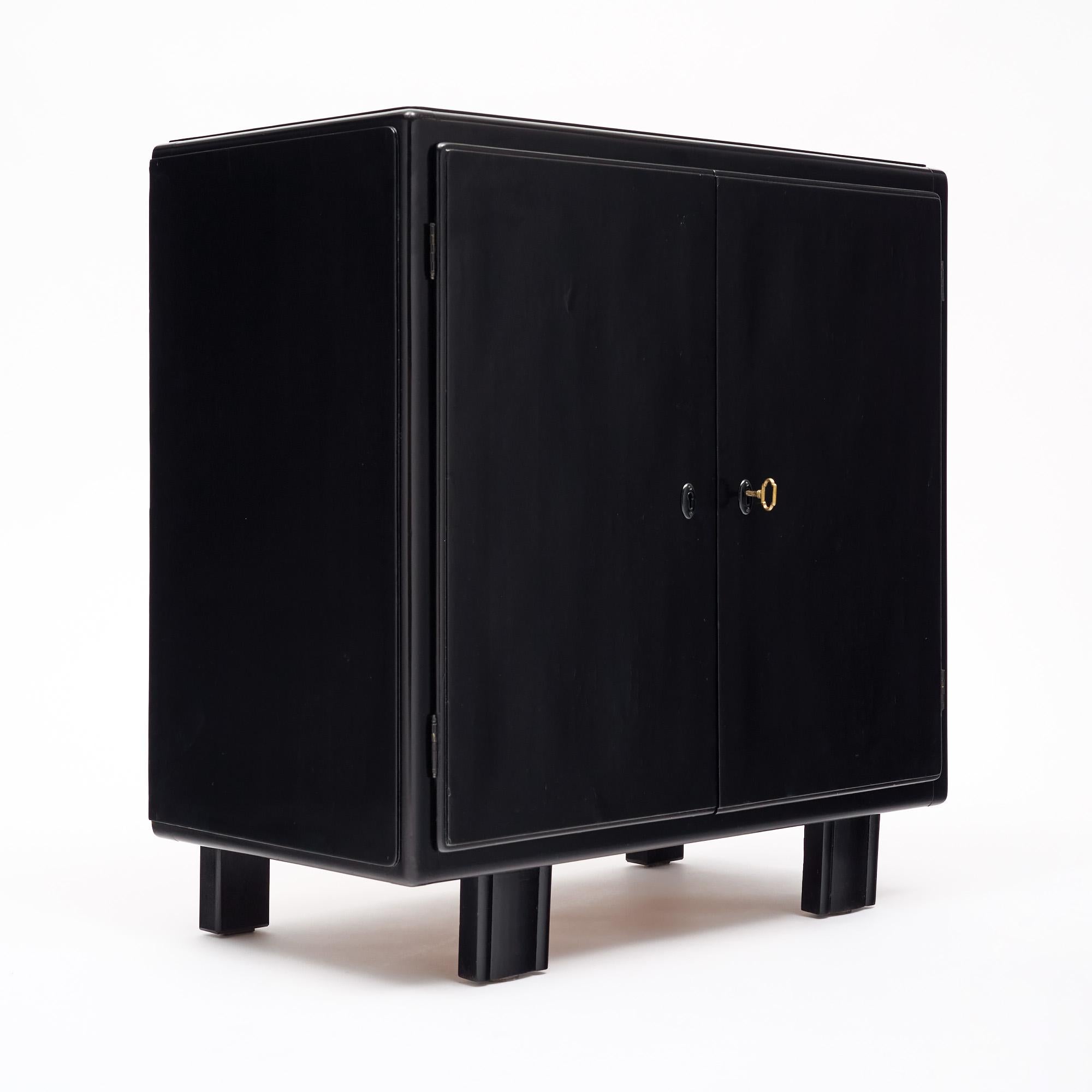 Mueble bar de la época Art Déco en Francia. Esta pieza está fabricada con madera maciza y chapa de caoba ebonizada y acabada con un lustroso pulido francés. Las dos puertas tienen una cerradura que funciona y la llave original. Se abren a un