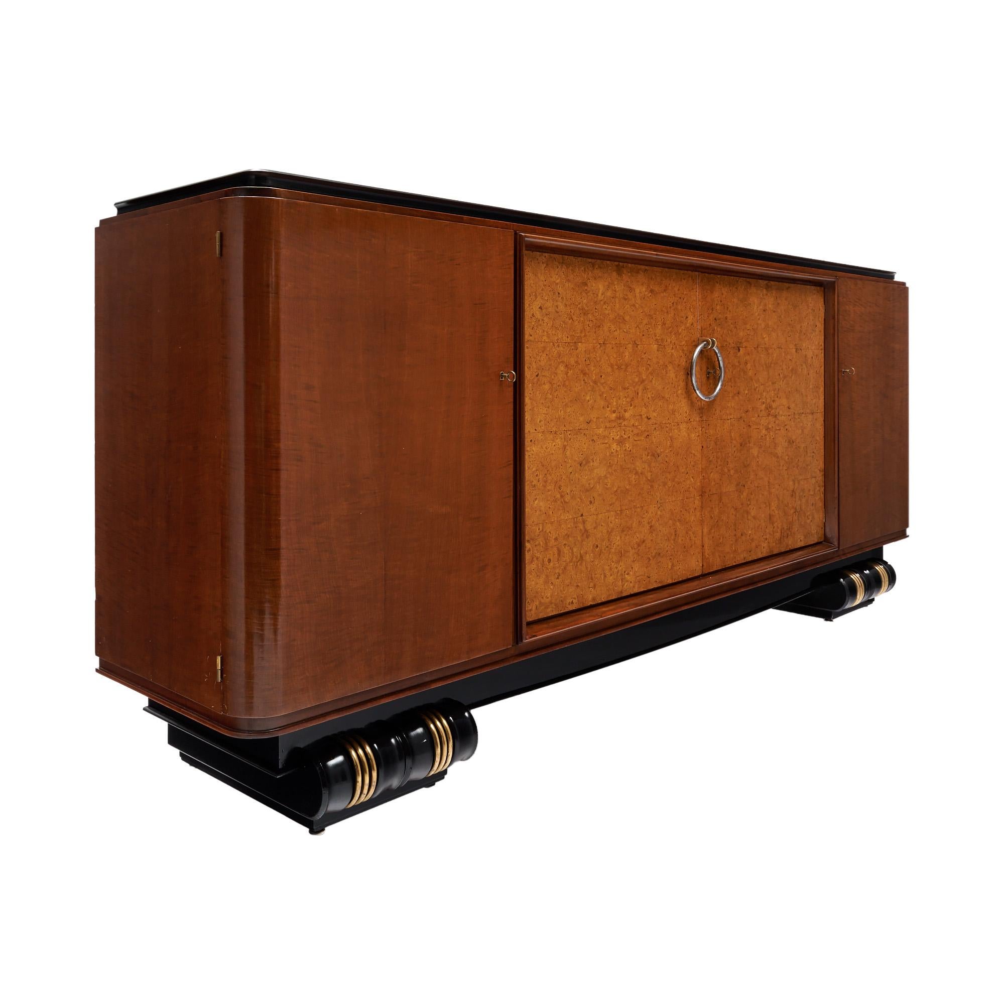 Buffet from the Art Deco period in France. This impressive piece is made of solid wood construction, Brazilian rosewood, burled Amboyna. It sits atop an ebonized base with brass detailing on the curved feet. The entire buffet has been finished with