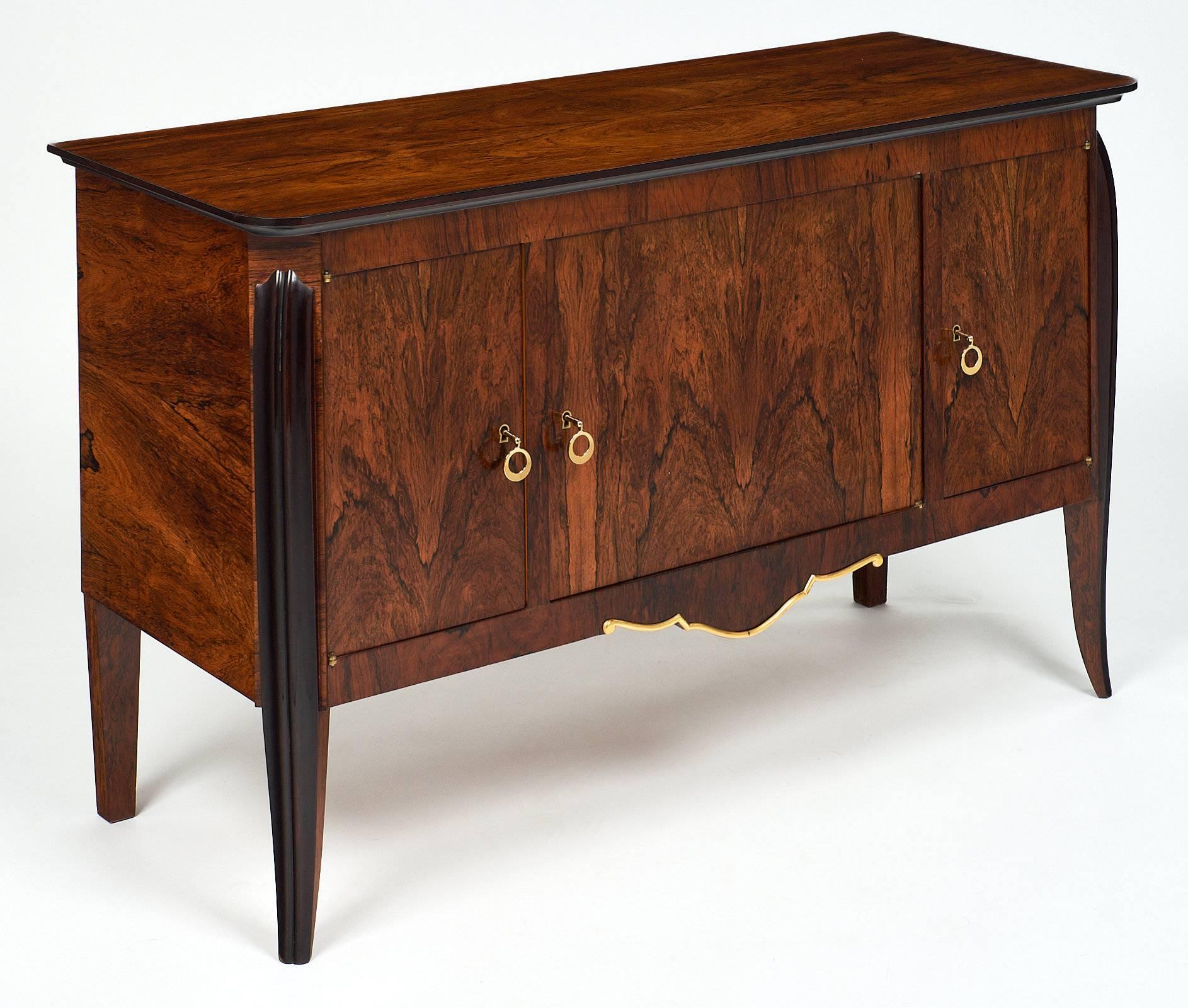French Art Deco period buffet in the manner of Emile Jacques Ruhlmann. A fine and rare small buffet or credenza of beautiful Brazilian rosewood with intense colors and contrasts. The ebonized curves on the front legs are reminiscent of the iconic
