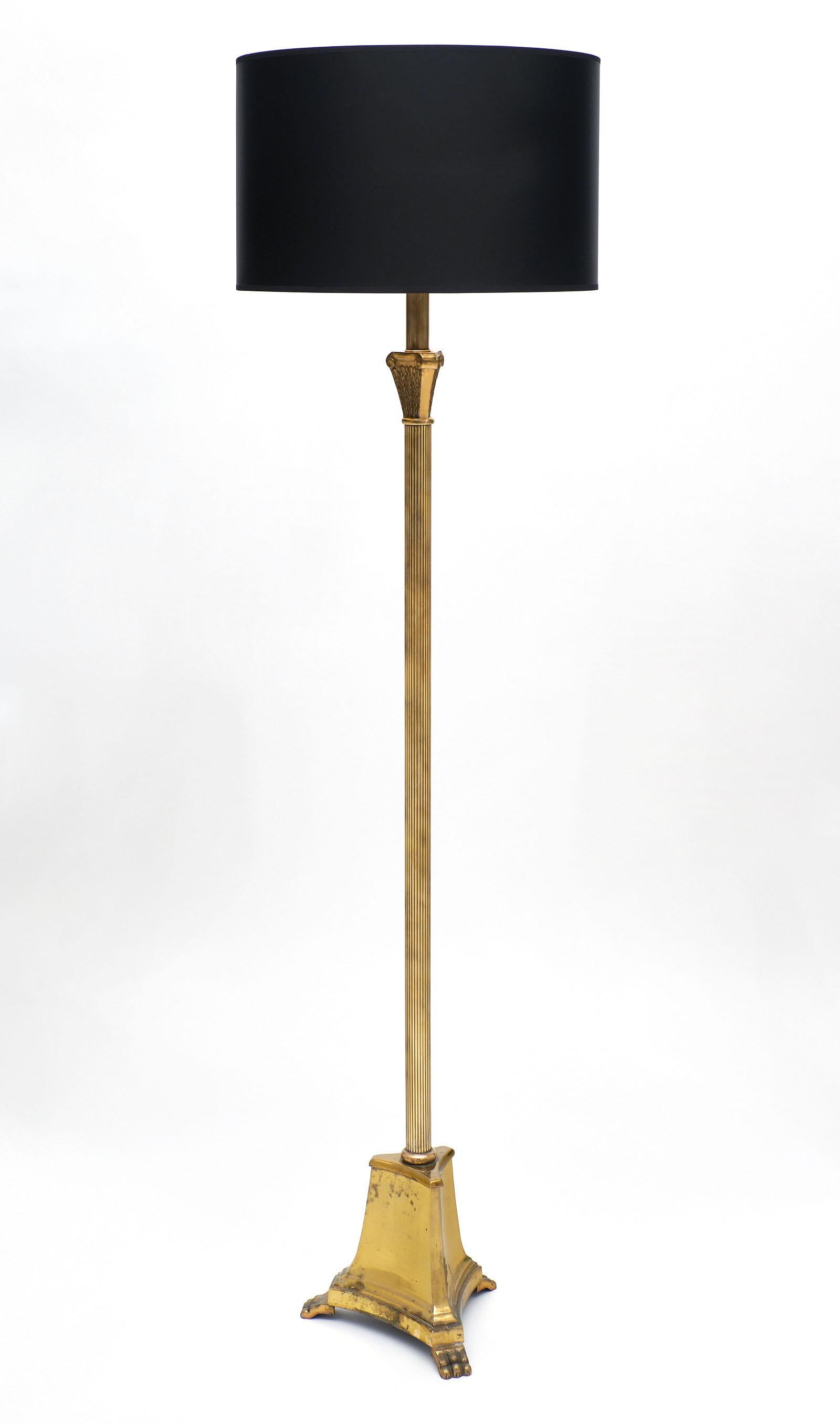 French Art Deco period floor lamp made of gilded brass and featuring a stylized tripod base with claw feet. We love the stylized Corinthian capital. It has been newly wired to fit US standards.