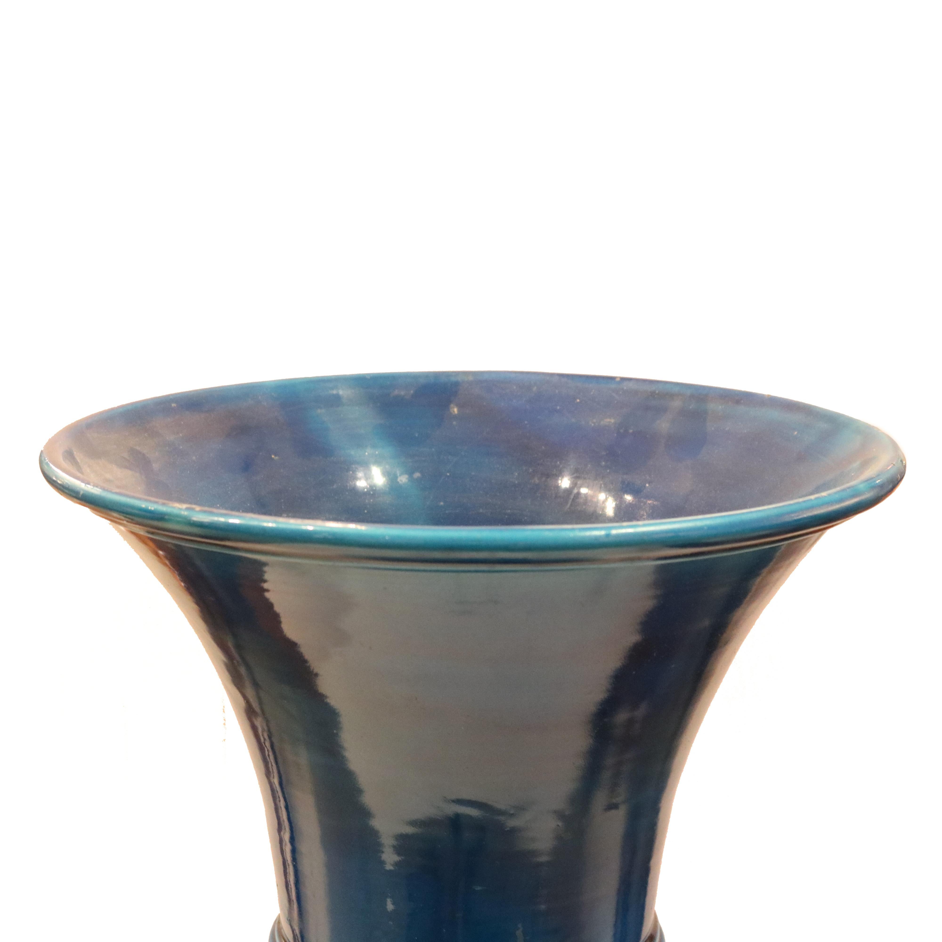 Vaso alto di epoca Art Déco francese, 1920 circa. La splendida ceramica smaltata di blu esalta la forma distintiva. La forma circolare permette al vaso di essere visto con lo stesso fascino da ogni direzione.

