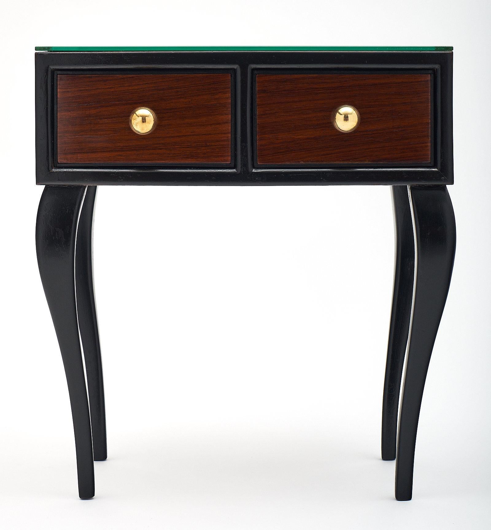 Pair of French Art Deco side tables from Nice, France. This pair is made of rosewood with beautiful ebonized cabriole legs. Each features two dovetailed drawers with brass spherical hardware. The mirrored tops give them a glamorous finish!