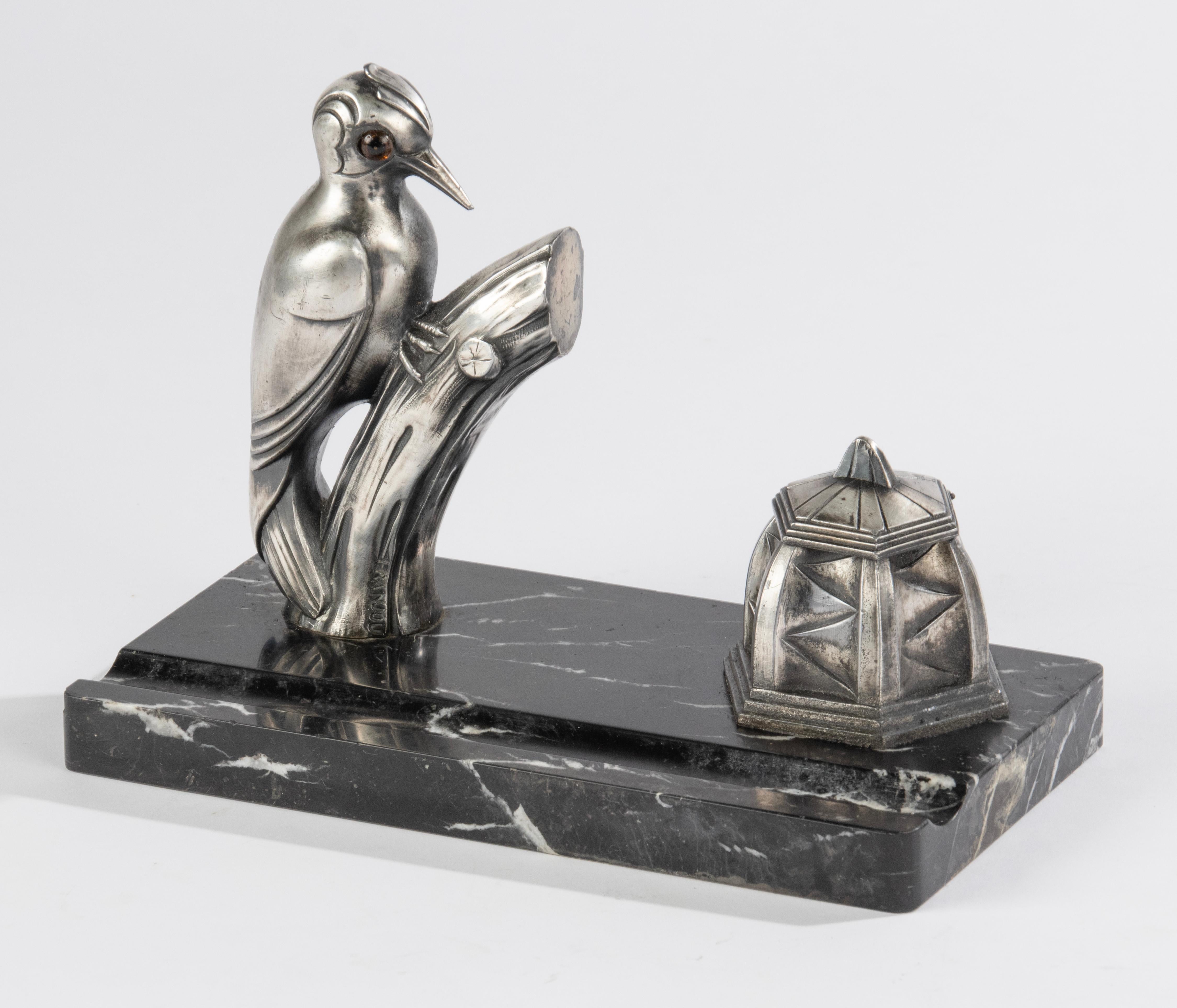 An Art Deco period inkwell, signed Franjou. With a figure of a woodpecker.  Made of nickel-plated spelter. On a marble plinth with fluting for a pencil.
Franjou is a pseudonym of the great French sculptor Hippolyte Moreau (1832-1926). Made in