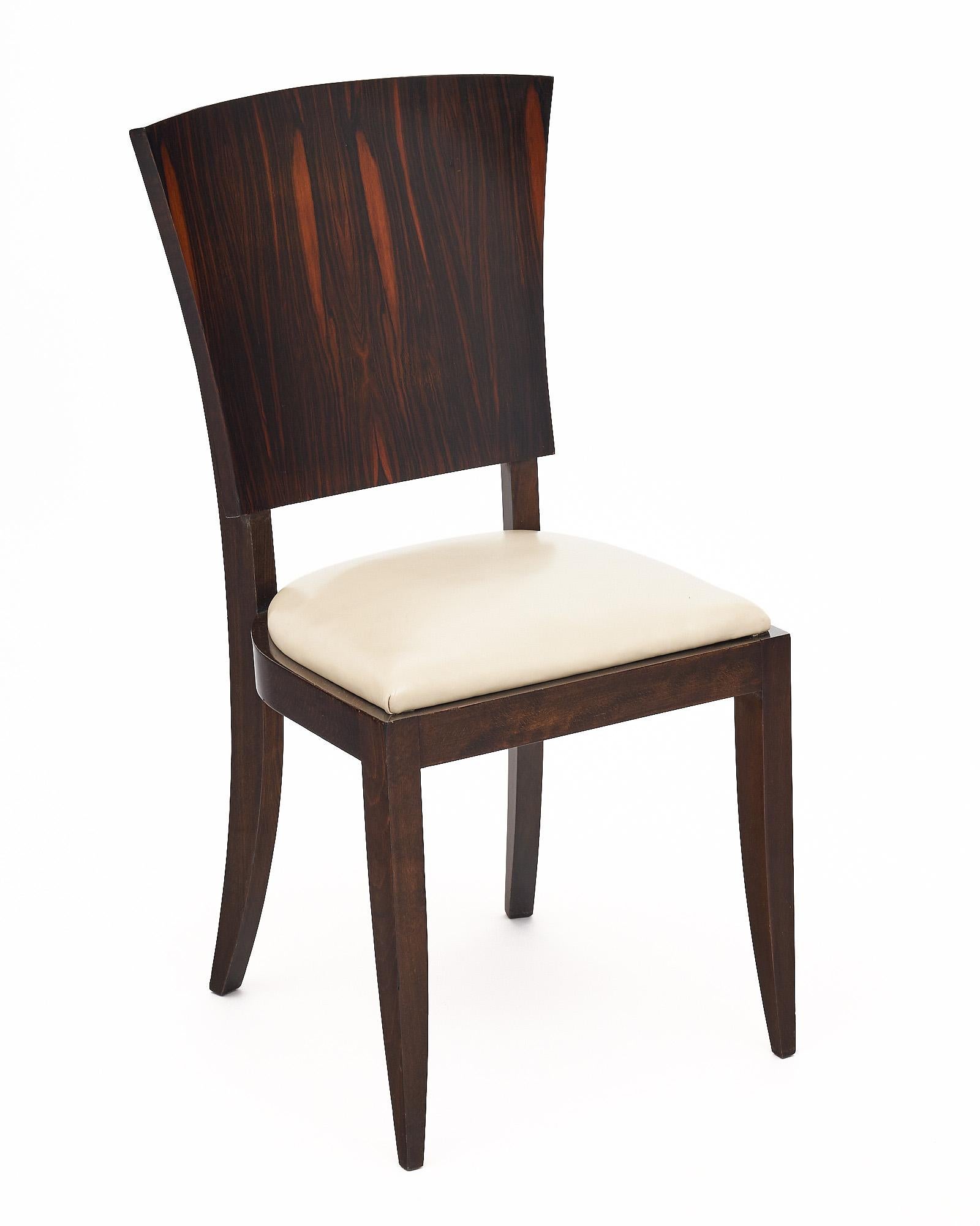 Set of six dining chairs from the Art Deco period in France In the manner of Jules Leleu. The chairs are made with striking Macassar of ebony backs and white leather seats. The chairs have been finished with a lustrous French polish.
