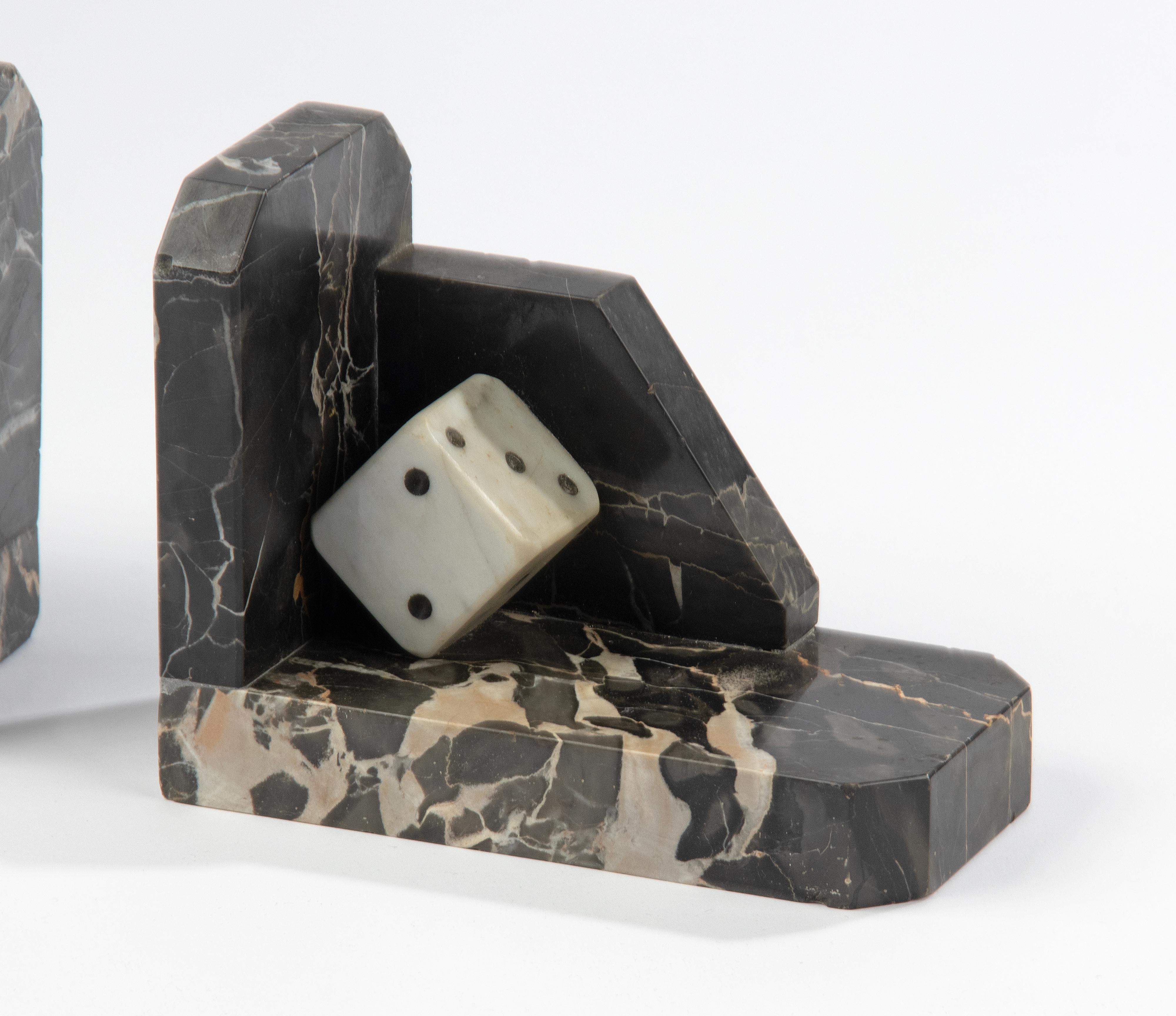 A pair of Art Deco period bookends with dice, made of Port Nero Marble, the dice are made of white Carrara marble. It is a decorative piece for on a desk or in the bookcase. Made in France around 1920-1920. Overall in good condition. Some tiny (old)
