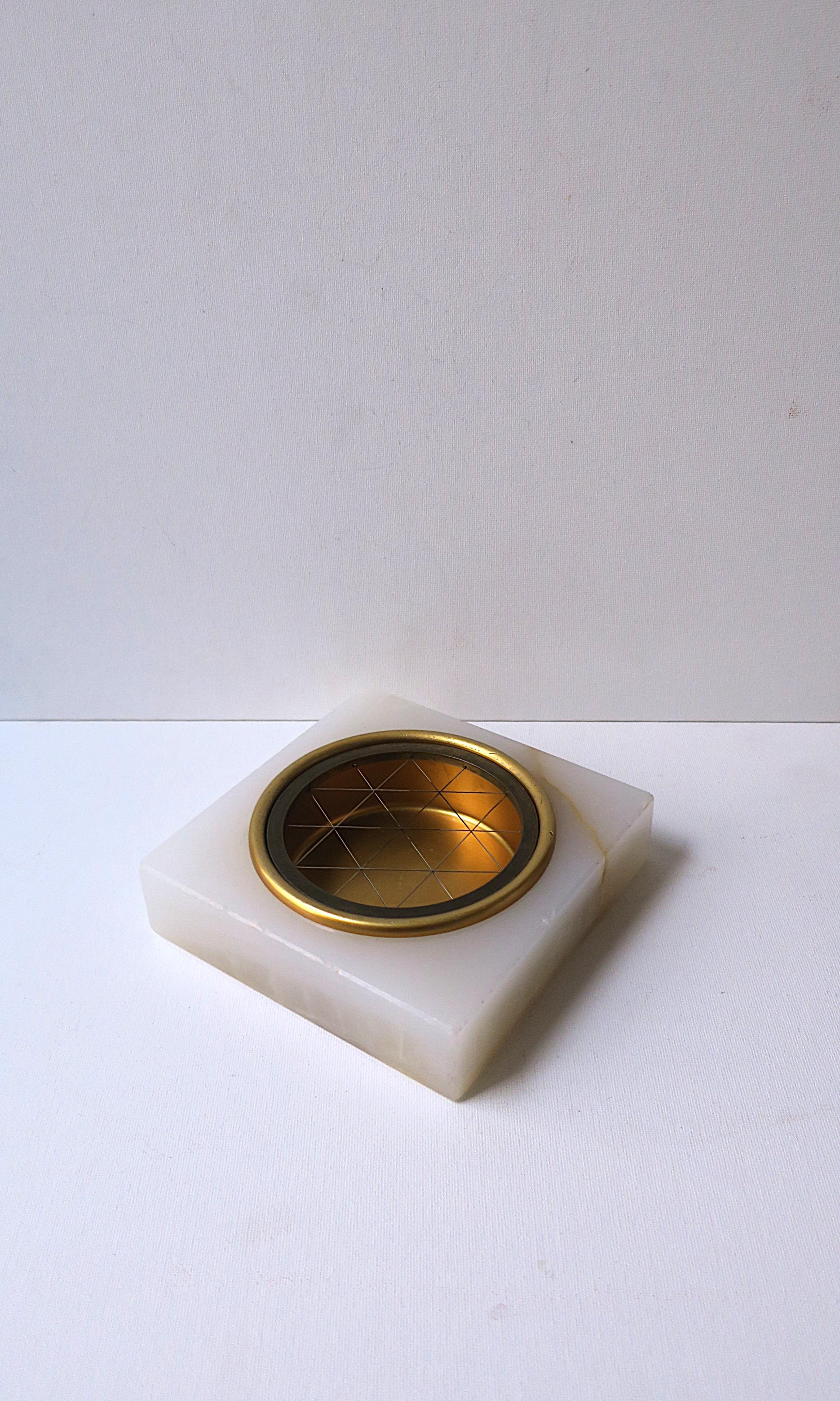 A substantial onyx ashtray, Art Deco design period, circa early to early mid-20th century, Europe. Piece is square, polished onyx, with a (removeable) grid top for extinguishing, and a round center area for depositing. 