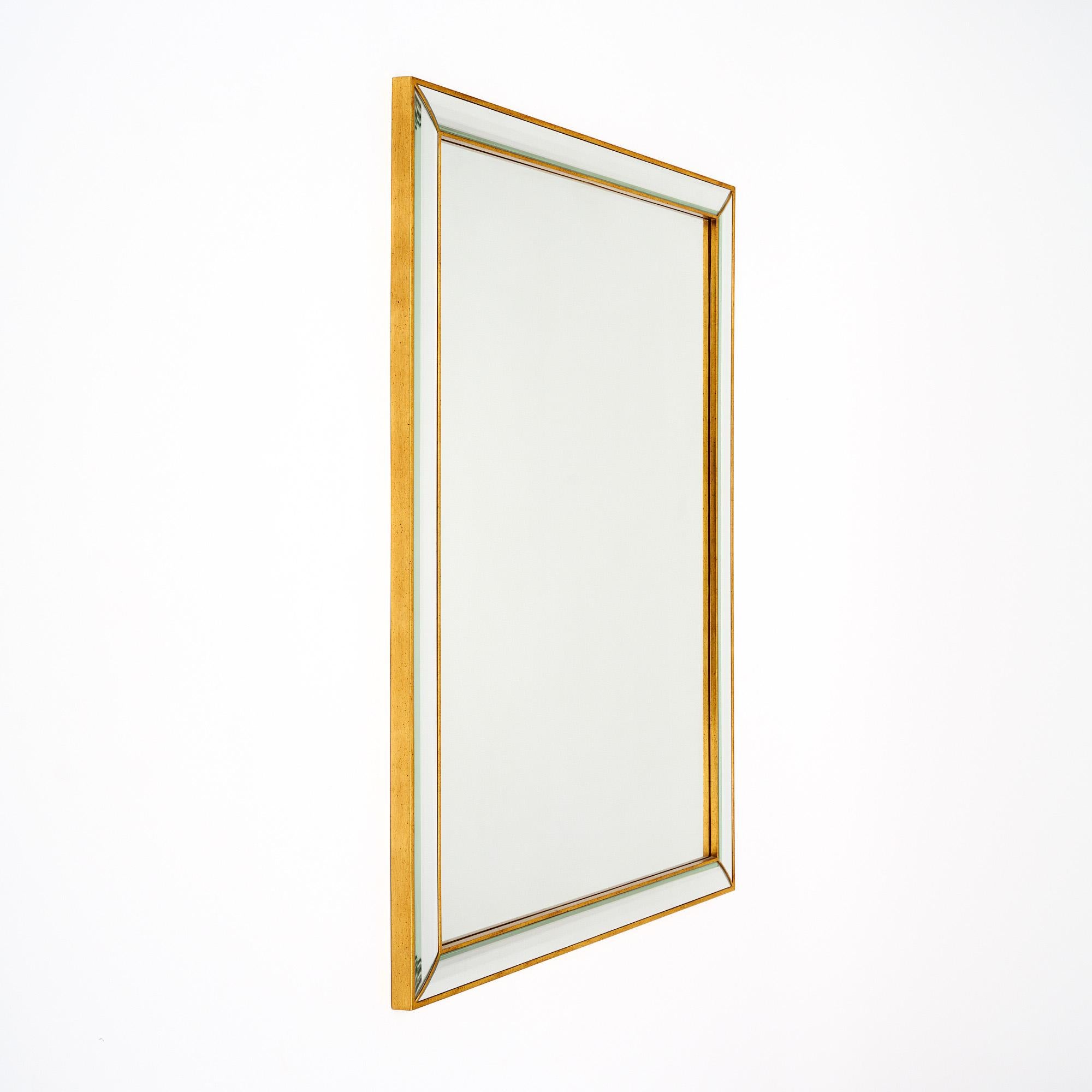 Art Deco period French mirror with a central rectangular mirror. The pareclose frame has a wood gold-leafed structure and beveled mirror pieces. This piece is in very nice vintage condition with only minor surface wear consistent with age and use.