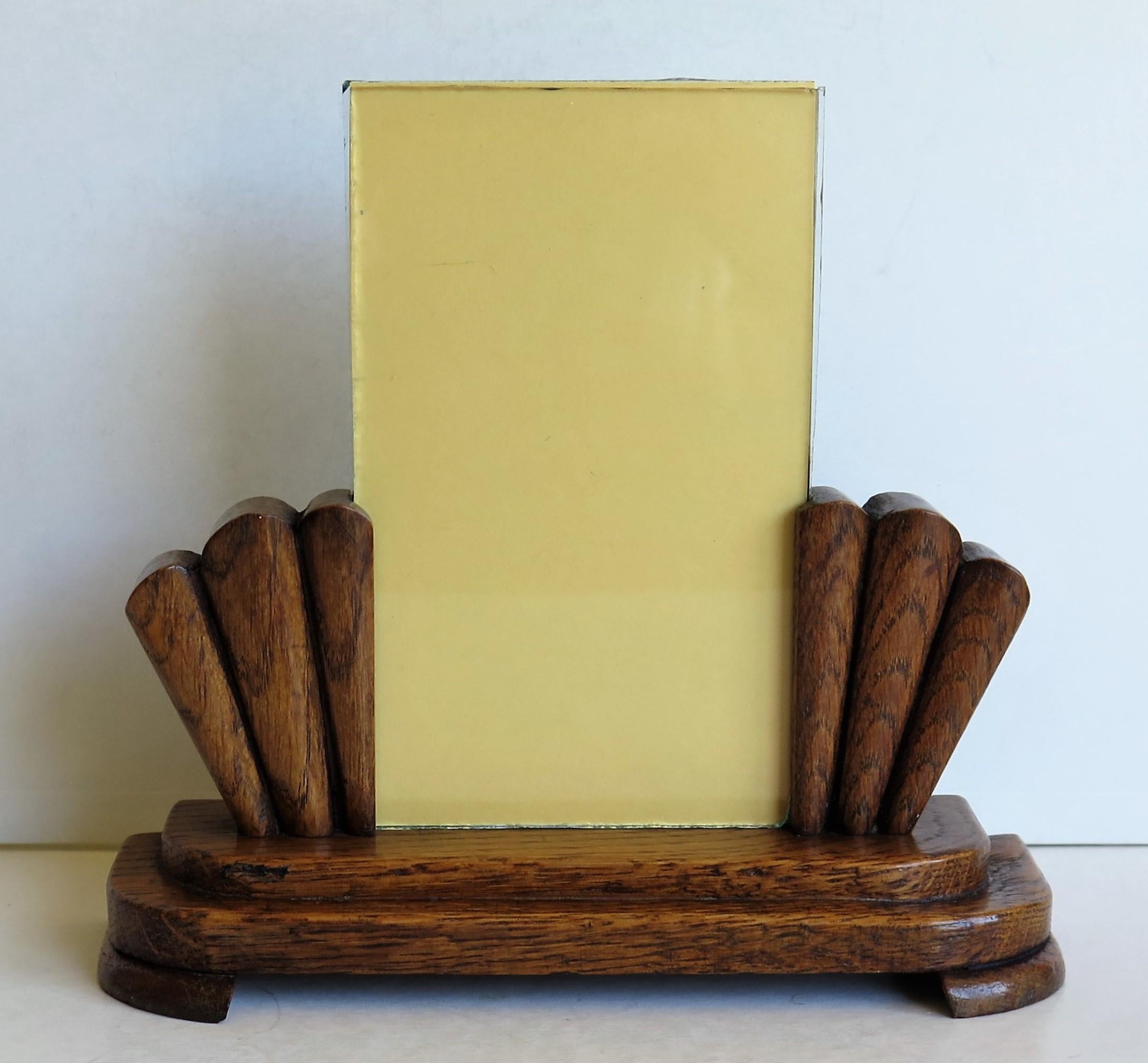 This is a beautiful photo frame from the Art Deco period, handmade from oak with a fan design and with two glass inserts, which we date to circa 1930.

This piece has been very well made out of oak, with angular fan shaped sides on a stepped base