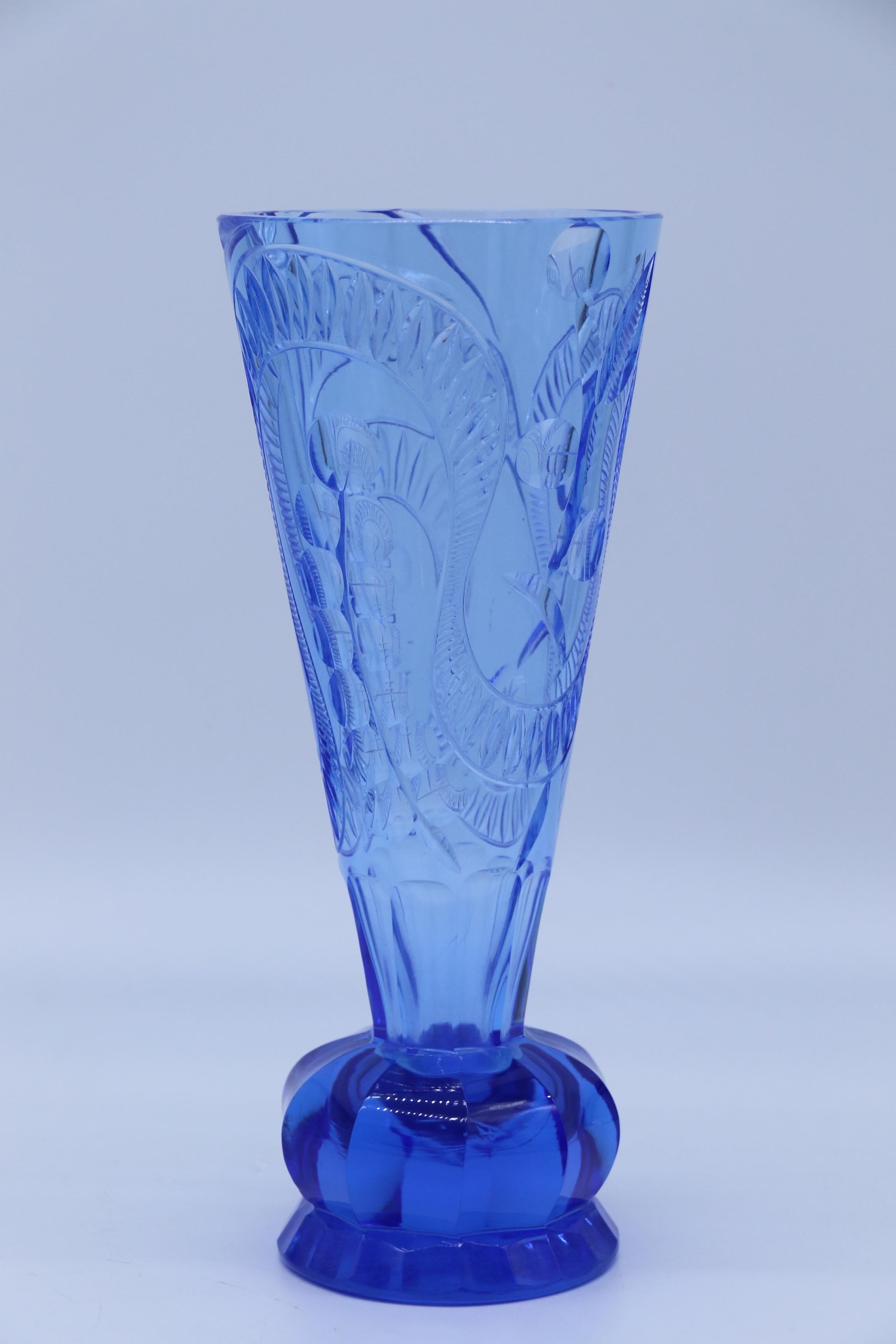 This remarkable vase dates to circa 1930.  It has a circular facetted foot and above a heavy solid glass base with ten scalloped sides around its circumference. The conical shaped vase rises elegantly straight up to the rim and is decorated with an