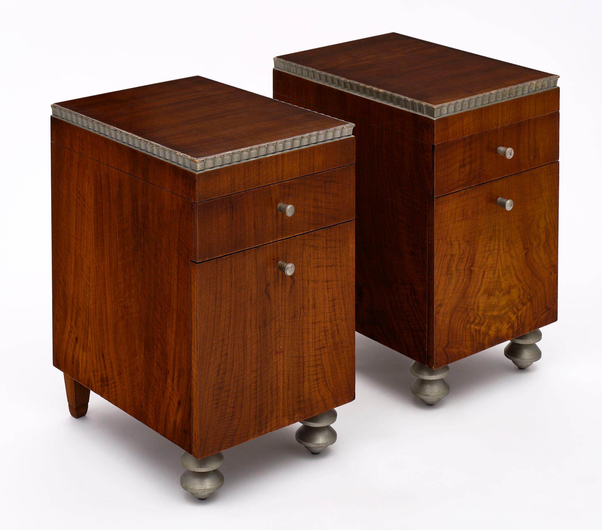 A pair of fine French Art Deco period side tables made of rosewood with silver leafed accents. Each night stand features a dovetailed drawer and a door for functionality.