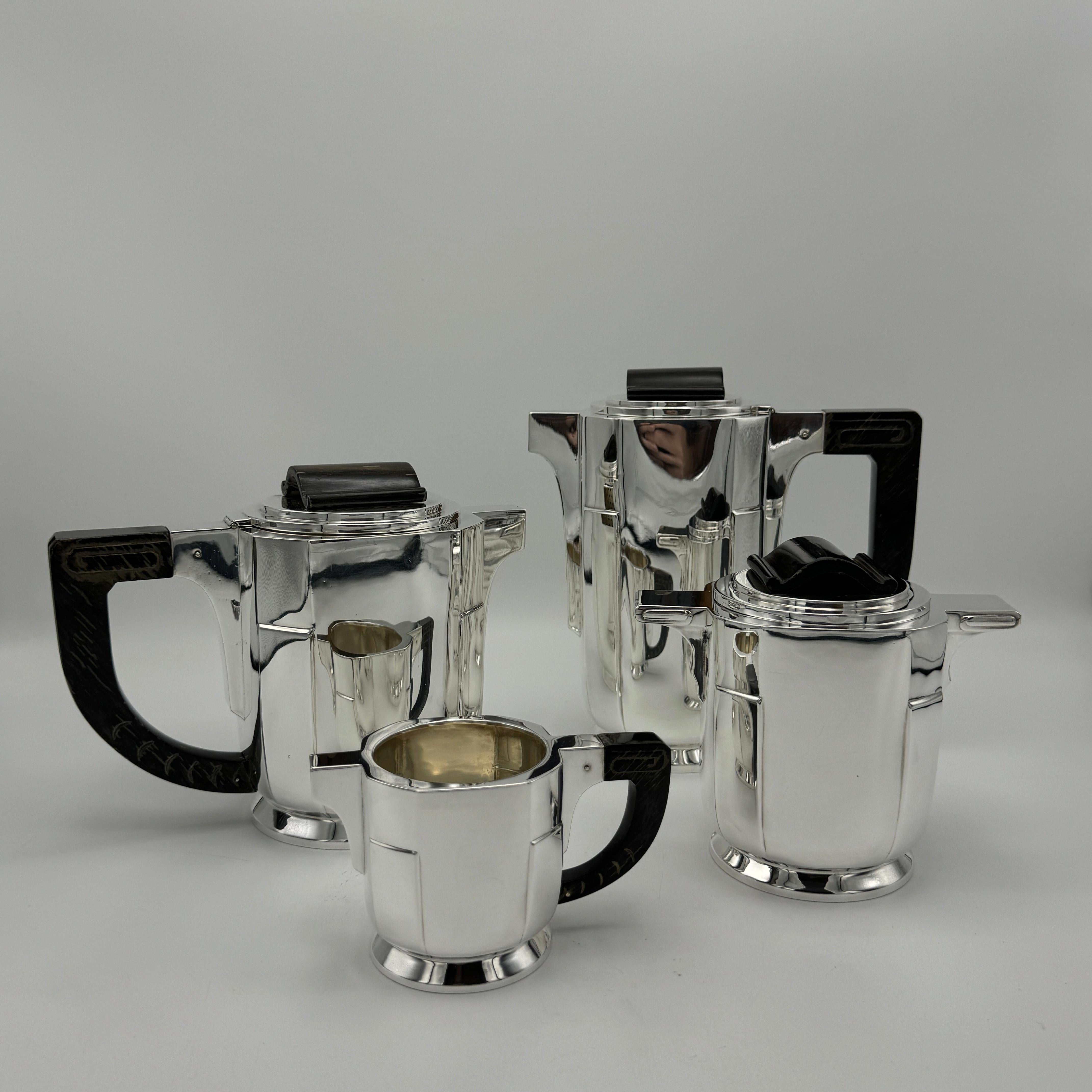 An Art Deco period sterling silver four pieces tea and coffee service from Brussels, Belgium circa 1930. This stunning set includes a coffee pot, a tea pot, creamer and sugar bowl in the distinctive machine industrial aesthetic of Art
