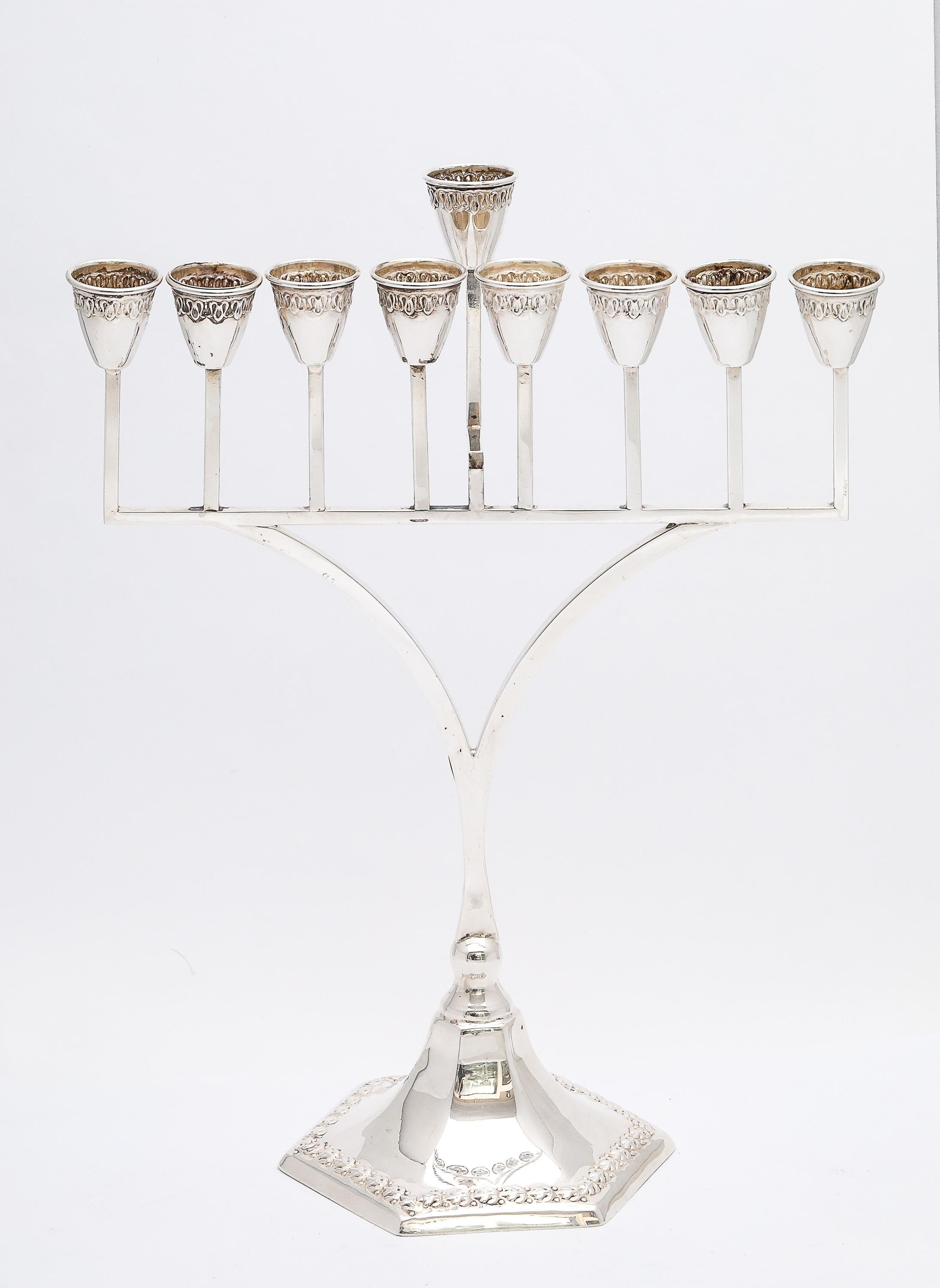 Menora aus Sterlingsilber, Art Deco Periode, amerikanisch, ca. 1930's. Die Menora steht auf einem sechseckigen Sockel, dessen Rand ein zartes Blumenmuster aufweist, und misst 10 1/2 Zoll Höhe (am höchsten Punkt - bis zur Spitze des abnehmbaren