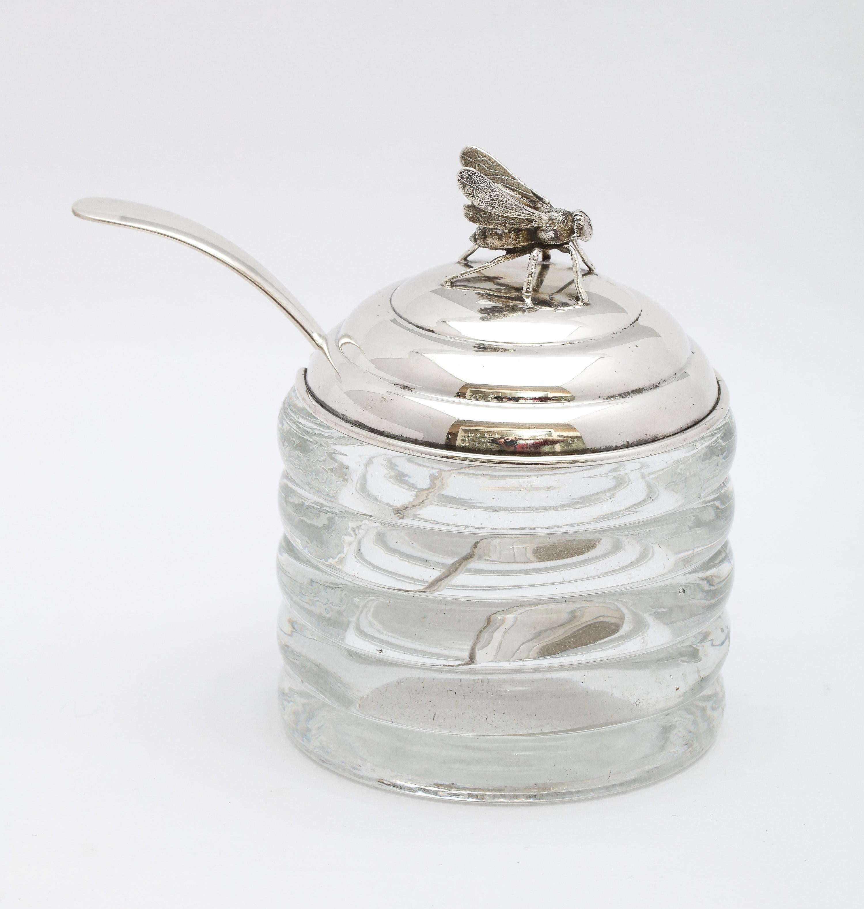 Art Deco Period, sterling silver-mounted honey jar with original honey spoon, R. Blackinton and Co., No. Attleboro, Mass., circa 1930s. Glass is beehive-form; sterling silver lid is topped by a honey bee. Underside of lid is lightly gilded. Measures