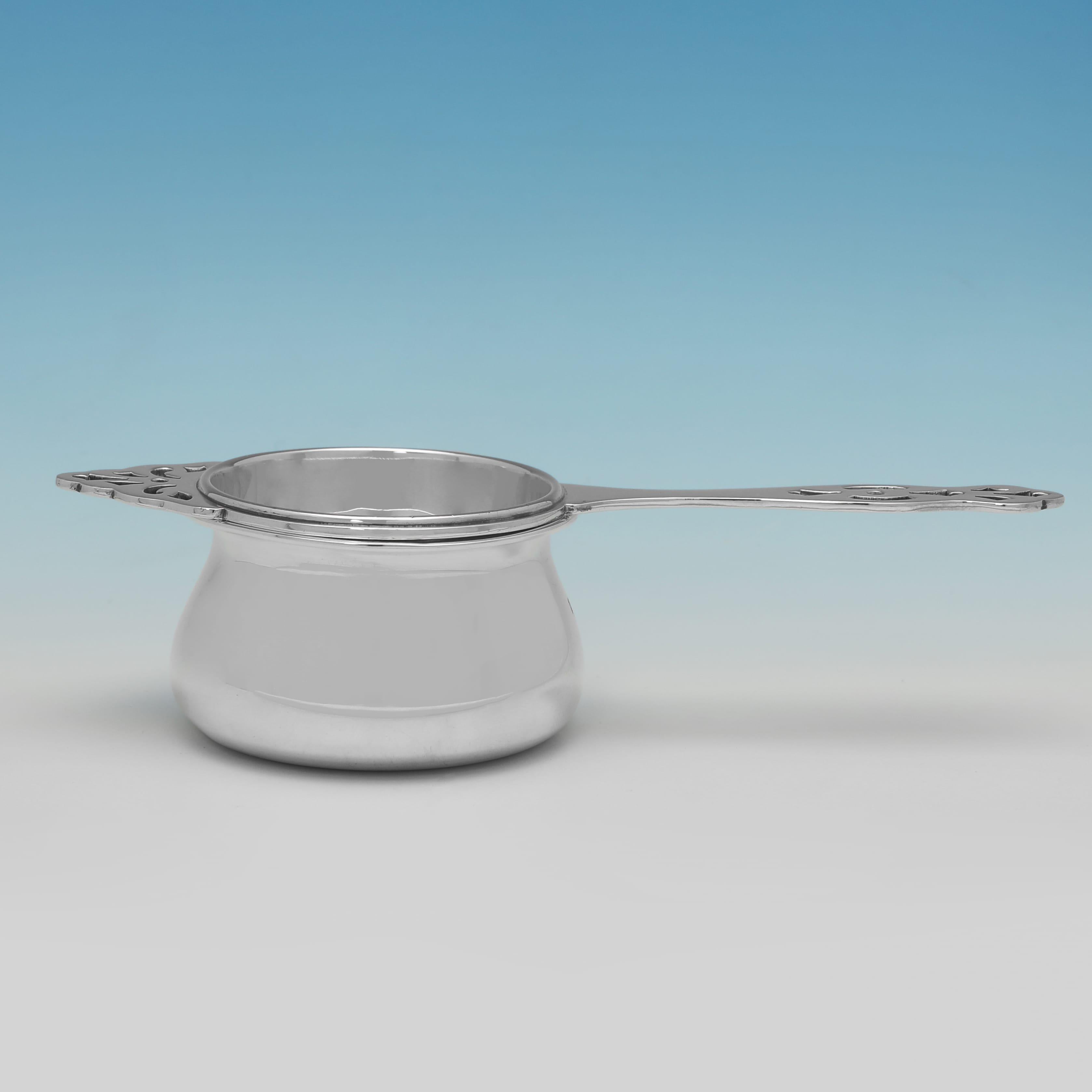 Hallmarked in Birmingham in 1938 by Barker Brothers Ltd., this George VI period, Sterling Silver Tea Strainer, features pierced detailing to the strainer, and a pain bowl. The tea strainer measures 1.5